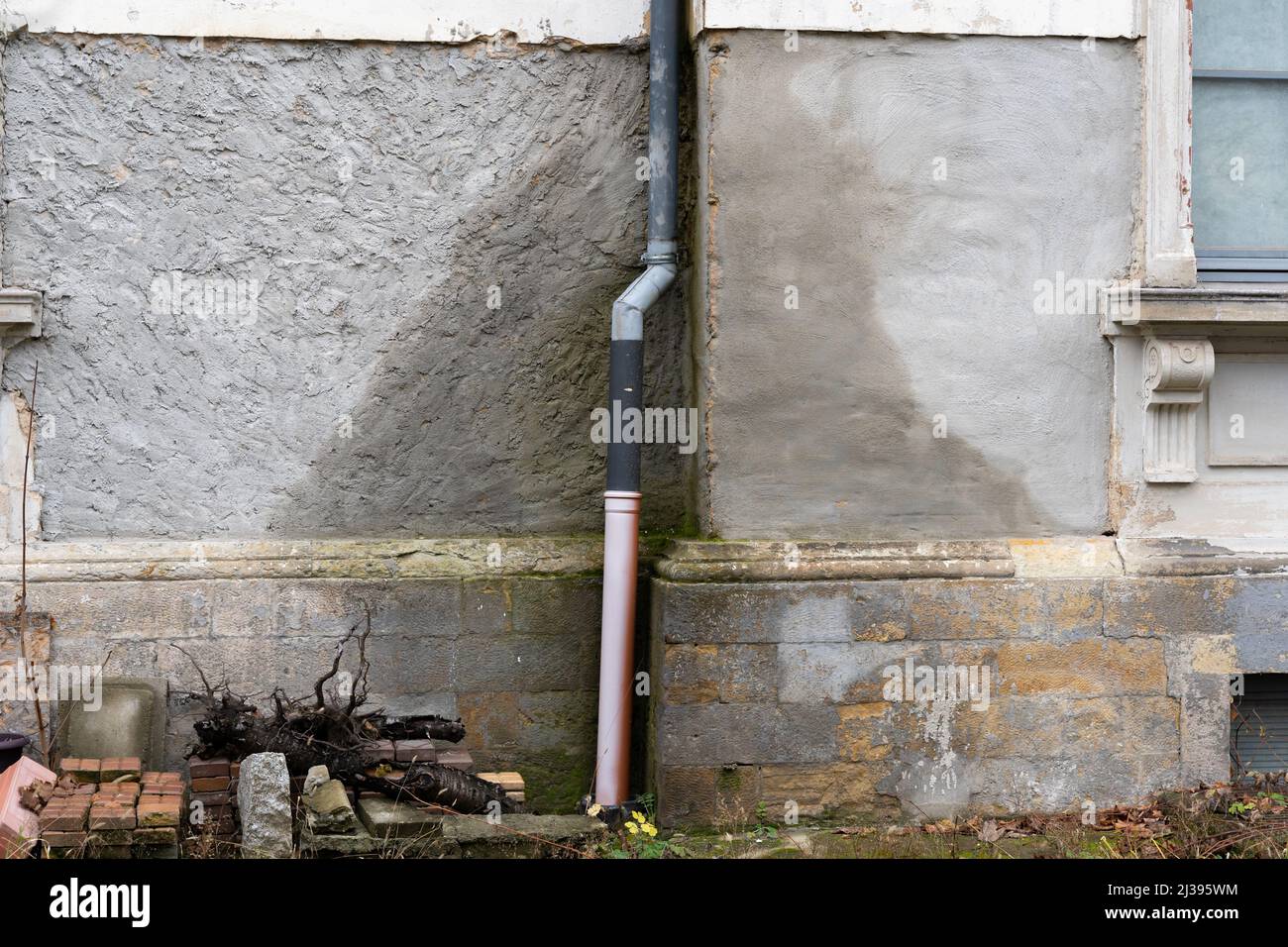 Wasserschaden eines Hauses. Nasse Außenwand, verursacht durch eine Leckage in einem Rohr der Dachrinne. Das Gebäude absorbiert Regenwasser. Kostenintensiv Stockfoto