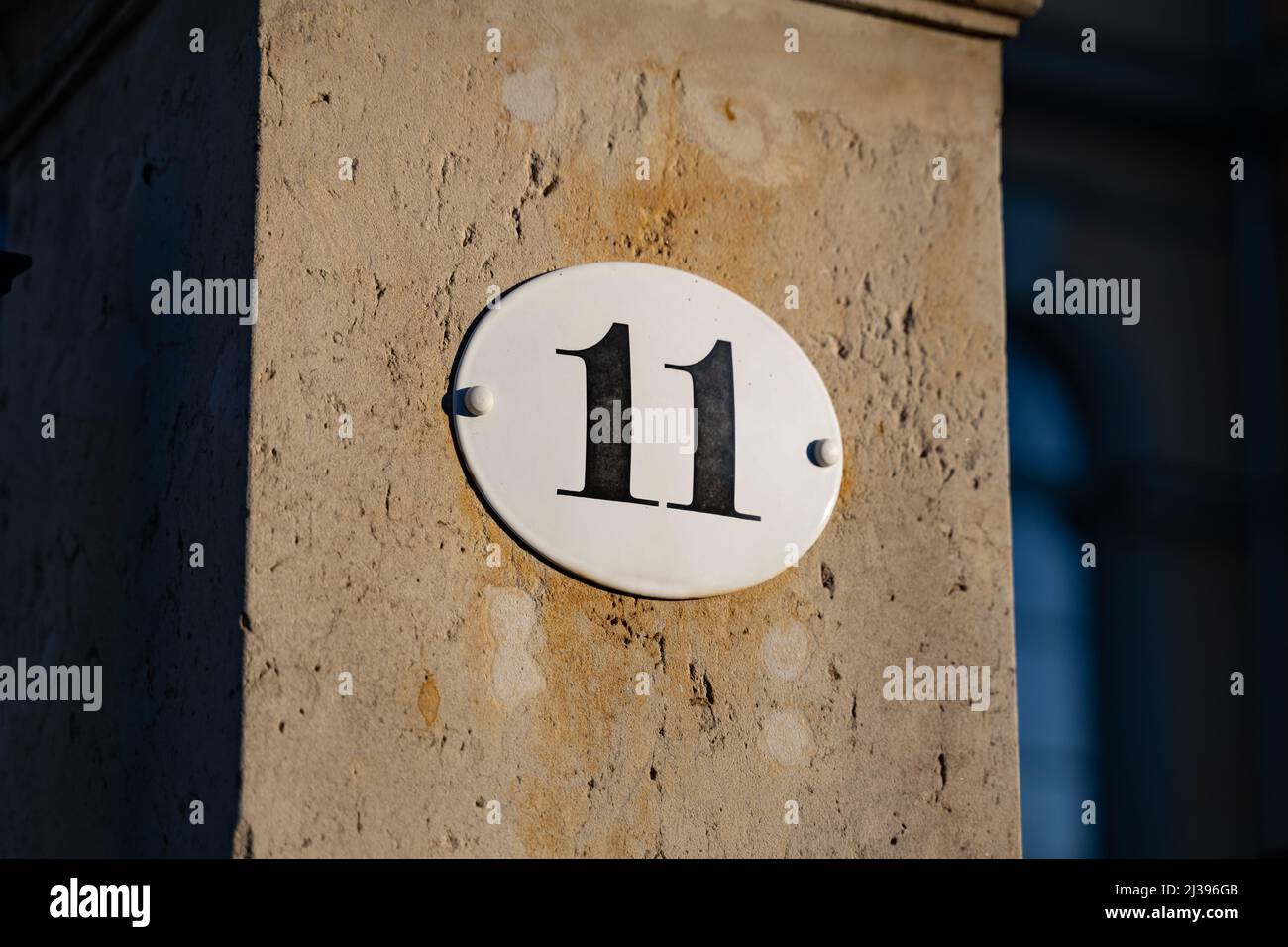 Die Nummer elf auf dem Teller auf der Wand. Haus Nr. 11 auf der Außenseite eines Gebäudes. Teil einer Adresse in einem Wohnviertel. Eingang eines Hauses. Stockfoto