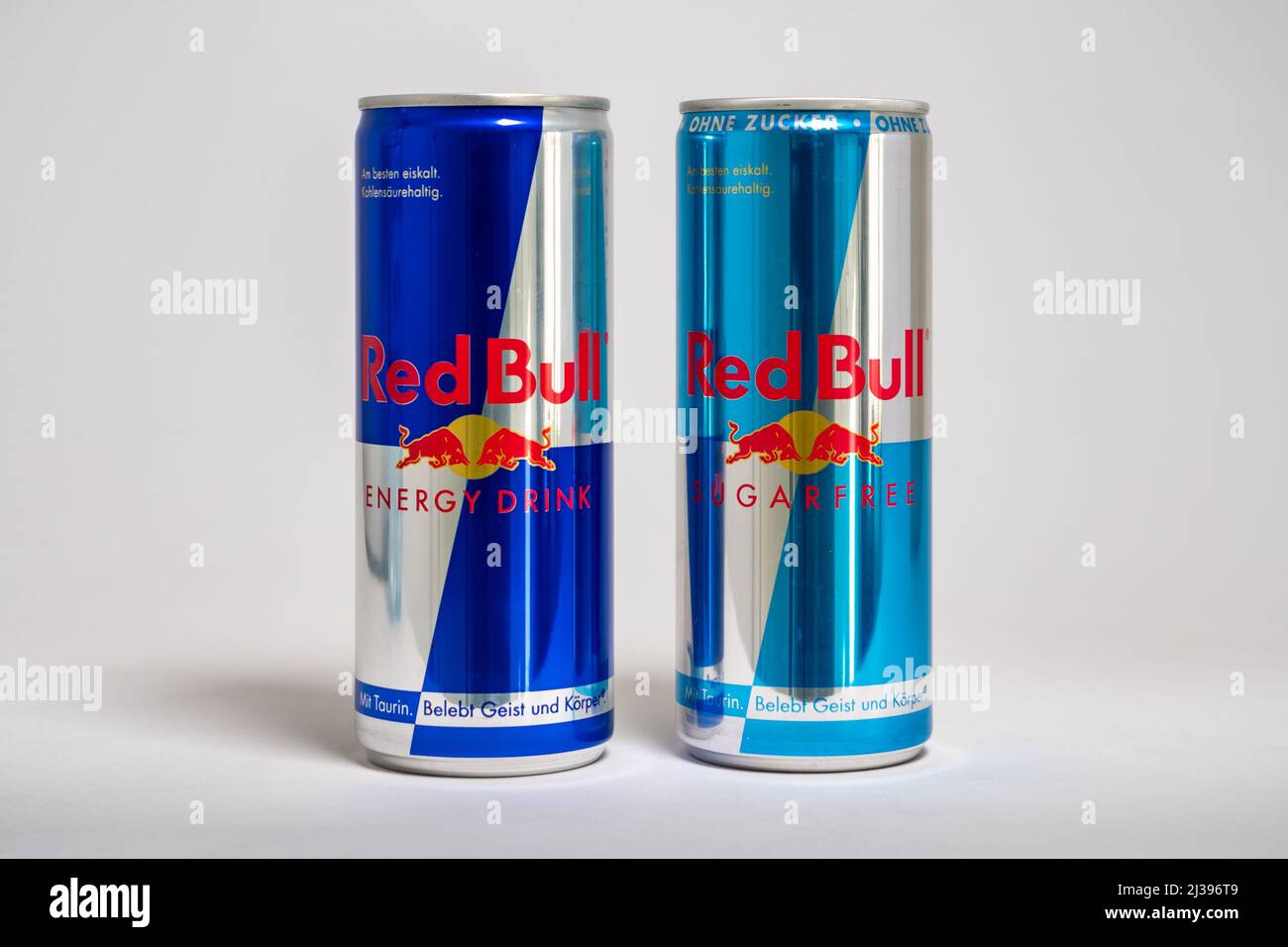 Red Bull Original- und zuckerfreie Dosen nebeneinander. Berühmte Energy-Drink-Marke in verschiedenen Variationen. Lifestyle-Getränk mit Koffein. Stockfoto