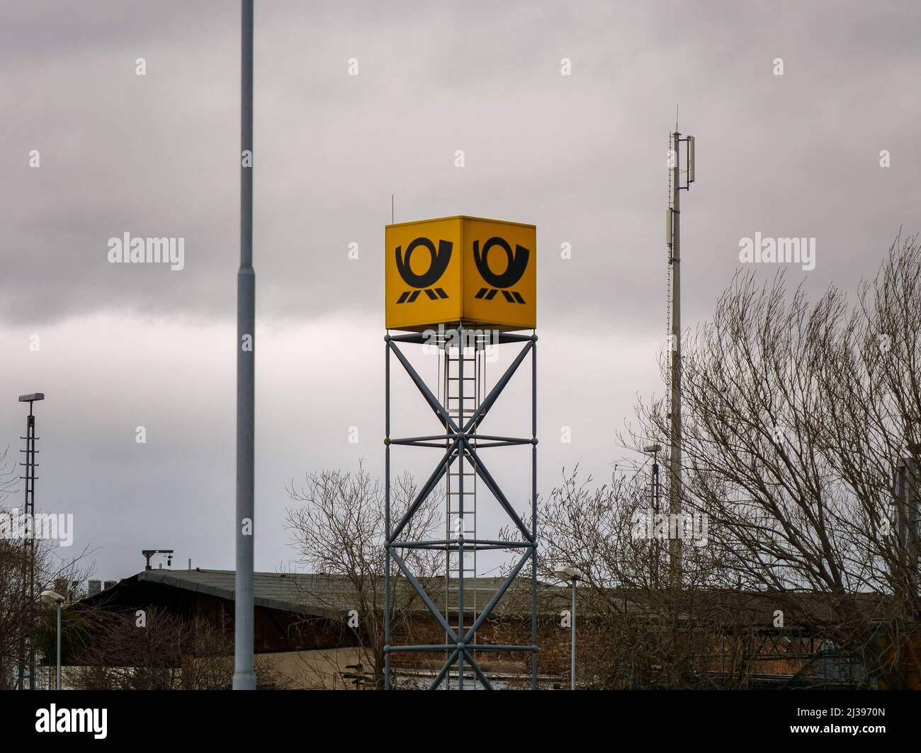 Logo der Deutschen Post DHL Group in einem Industriegebiet. Lieferfirma für den internationalen Paketversand. Gelber deutscher Kurier Stockfoto