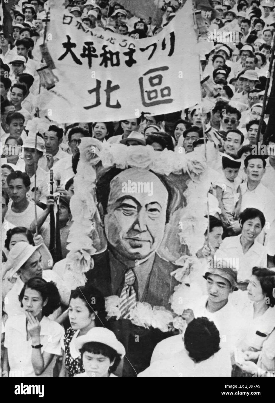 Japanische Kommunisten feiern 30.. Jahrestag: Teil der Menge, die ein blühendes Porträt des Führers der japanischen kommunistischen Partei zeigt und trägt. Die japanische Kommunistische Partei feierte vor kurzem ihren 30.. Jahrestag mit einem Treffen im Edogawa Park, Nordost-Tokio. Es waren mehr als 15.000 Menschen da. Die Kundgebung war für den 5. Juli geplant, aber da sich die Eigentümer weigerten, alle Treffpunkte zur Verfügung zu stellen. Sie musste auf den 24. August verschoben werden. 6. September 1952. (Foto von Paul Popper). Stockfoto