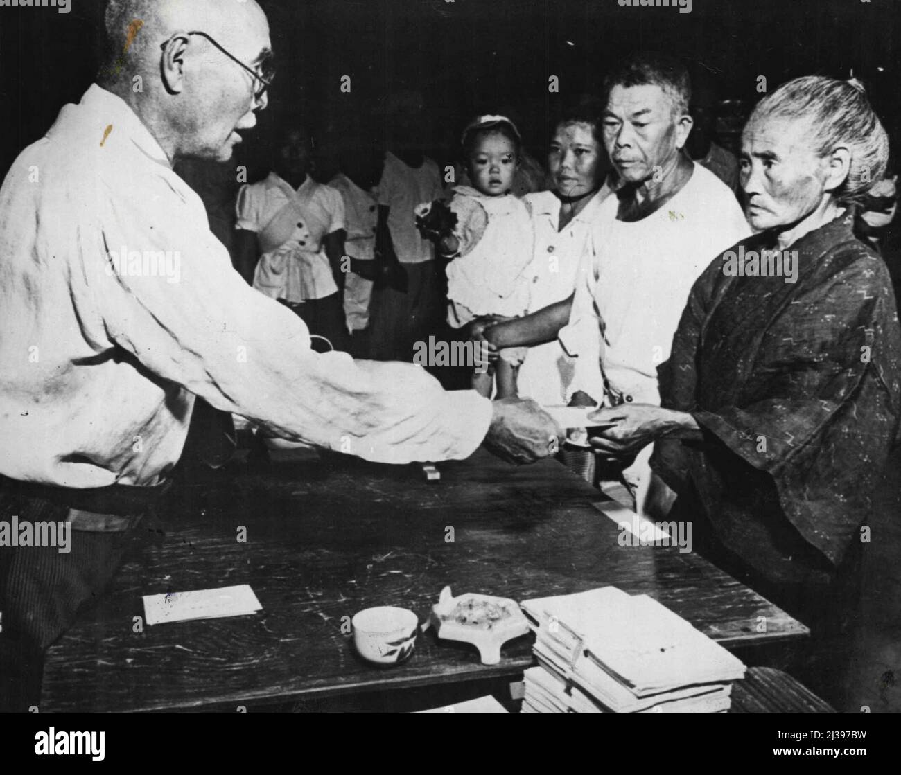 Die Japaner wählten Einen Gouverneur: Alle Altersgruppen waren vertreten ***** Gouverneur der japanischen Präfektur Okinaw in der Stadt Nago im Norden von Okinawa. Junge Mütter mit Babys, die den älteren Großmüttern auf den Rücken geschnallt waren, als Okinawanen zum ersten Mal zur Wahl ihres Gouverneurs gingen. Dies ist das erste Mal, dass japanische Frauen am 9.. Oktober 1950 in der Lage waren. 18. Oktober 1950. Stockfoto