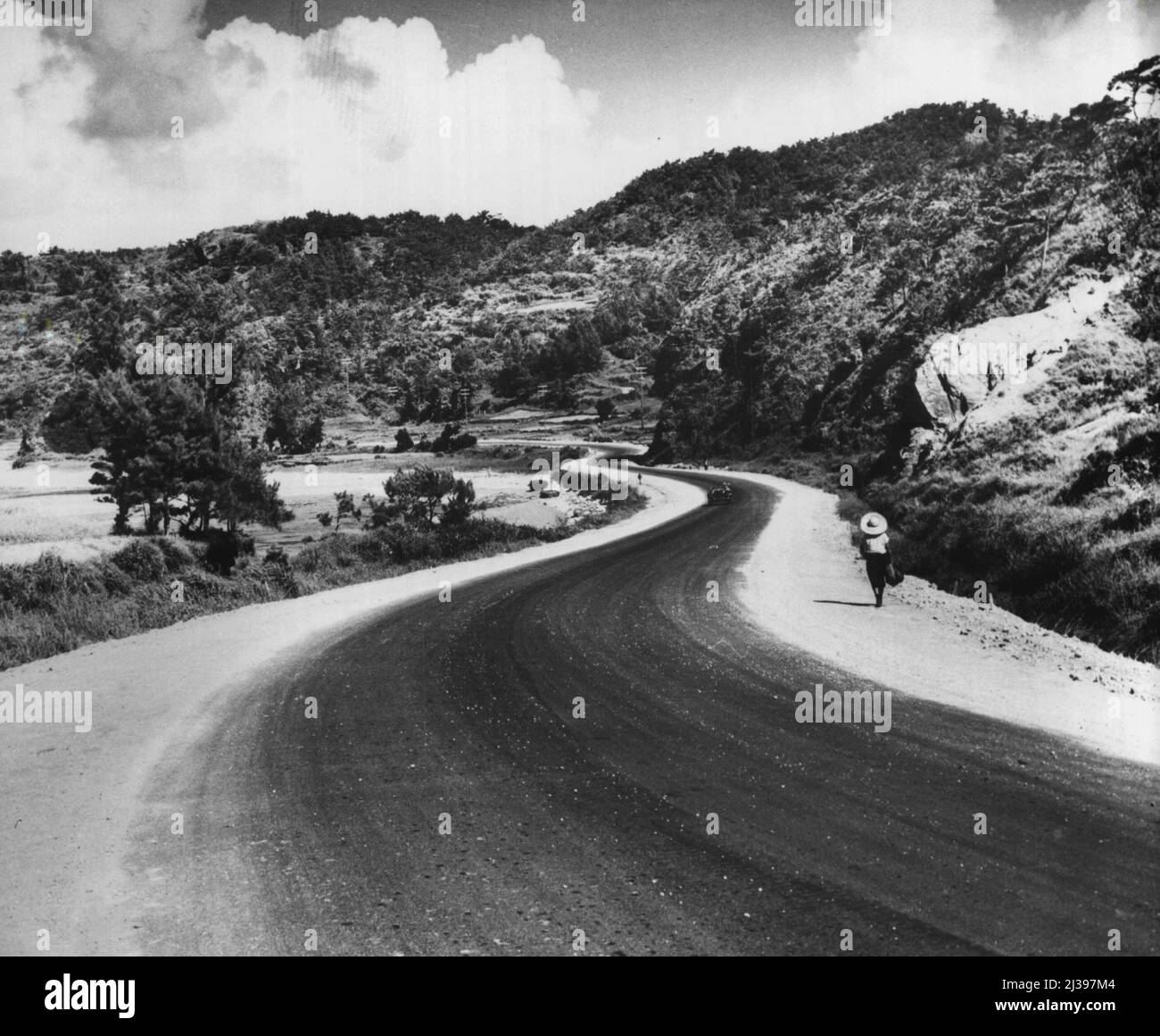 Okinawa: Zehn Jahre später -- die Hochgebiete sind eine attraktive Aussicht und die Fahrt auf Straßen wie dieser in der Nähe von Fort Buckner macht es leicht. Es gibt viel Platz auf dieser abgelegenen, sekundären Straße, die mit einem Netzwerk von vierspurigen Super-Highways verbunden ist, die zu allen auf dem US-Festland passen. 06.Mai 1955. (Foto von U.S. Army Photo). Stockfoto