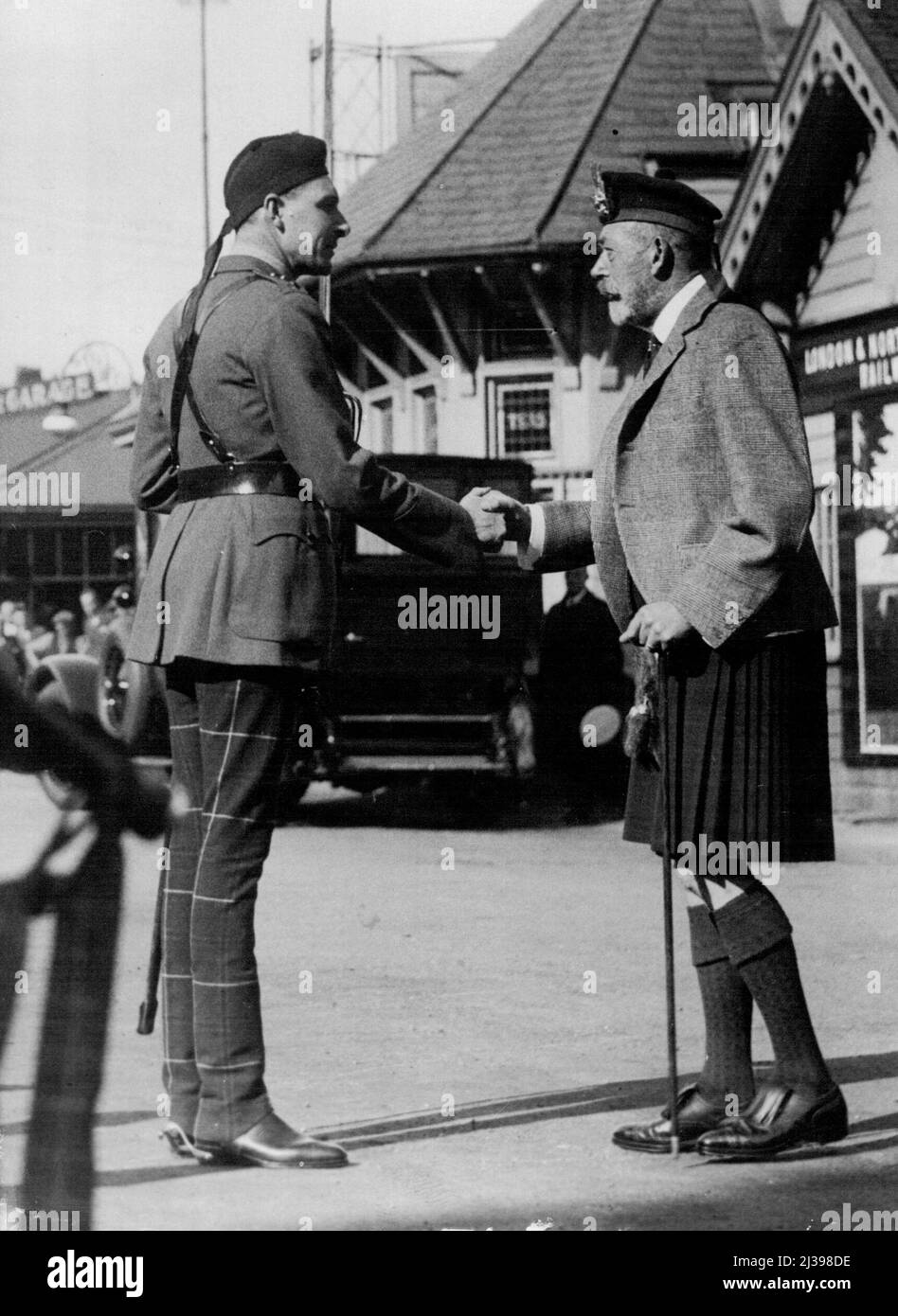 Der König in Schottland. Der König grüßt Kapitän D.F. Campbell, M.C., von den Cameronians, die eine Ehrenwache bildeten, als seine Majestät gestern, 24. August, in Ballater, Schottland, eintraf. 9. Oktober 1933. (Foto von Associated Press). Stockfoto