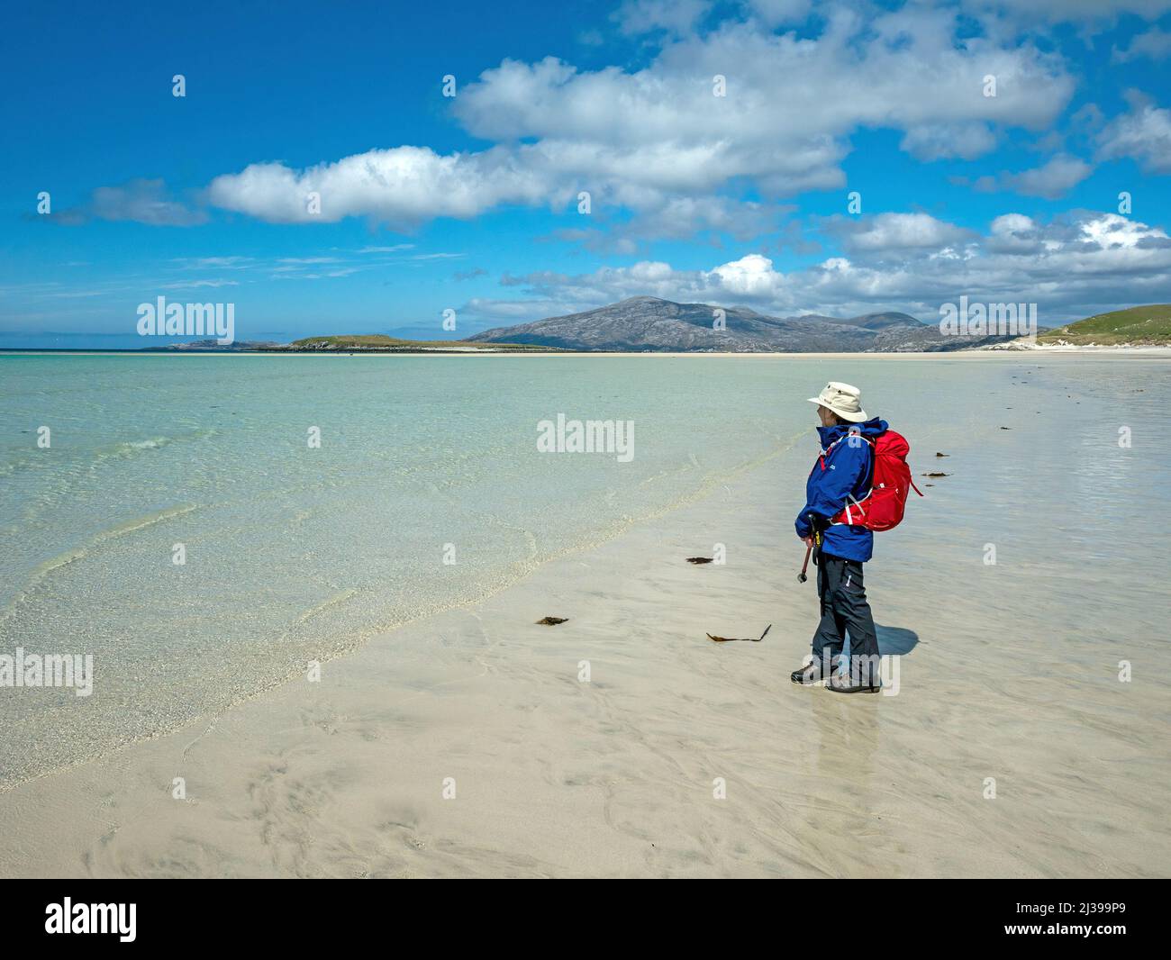 Weibliche Touristin am abgelegenen Sandstrand von Traigh Mheilein in der Nähe von Hushinish auf der Isle of Harris in den Äußeren Hebriden an einem kalten Maitag, Schottland, Großbritannien Stockfoto