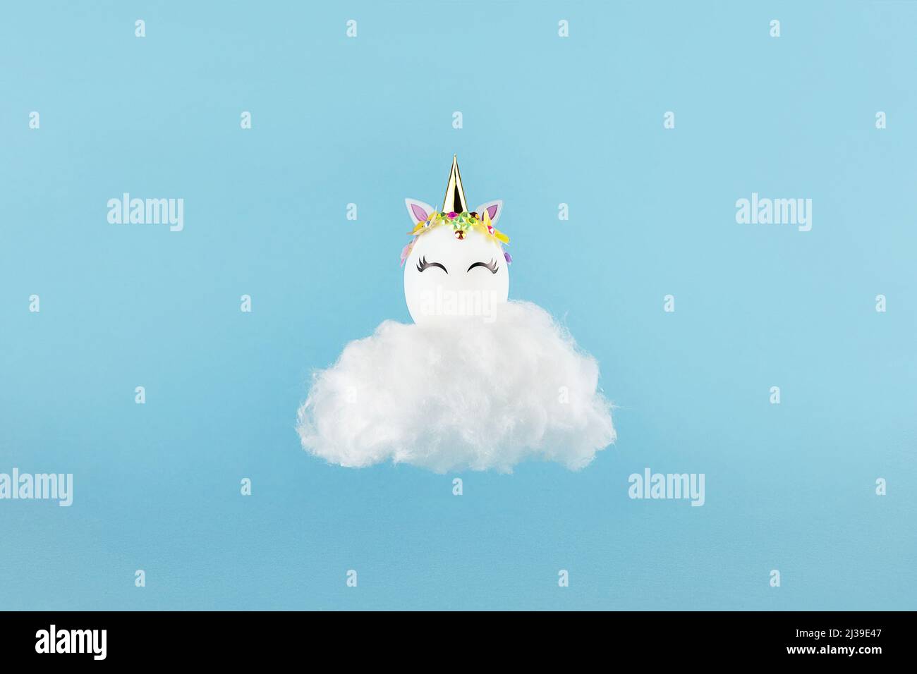 Ostereinhorn-Ei fliegt auf blauem Hintergrund. Frohe ostern Banner. Inspiration für Aktivitäten für Kinder. Grußkarte oder Poster. Platz für Text kopieren. Levitation Stockfoto