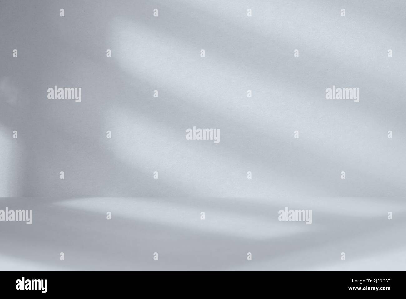 Leerer grauer Studiobereich mit tiefem künstlerischen Schatten. Minimalistisches Raumkonzept Stockfoto