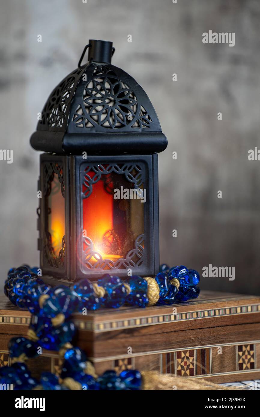 Ramadan Laterne erhellen und ein Blauer arabischer Rosenkranz über einer Arabeske Box in einer Vintage-Stimmung oder Umgebung . Stockfoto