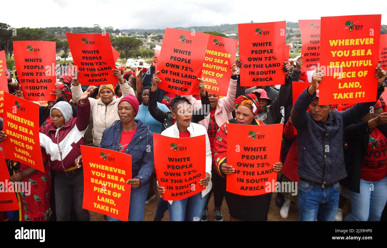 Stellenbosch, Südafrika. 6. April 2022. Mitglieder der südafrikanischen Partei Economic Freedom Fighters (EFF) halten Plakate vor ihrem marsch am 6. April 2022 in Stellenbosch, außerhalb von Kapstadt, Südafrika. Südafrikas drittgrößte politische Partei, Economic Freedom Fighters (EFF), marschierte am Mittwoch zum Büro von Johann Rupert und bat ihn, die reichste Person des Landes, sein Land an Schwarze freizulassen. Kredit: Xabiso Mkhabela/Xinhua/Alamy Live Nachrichten Stockfoto