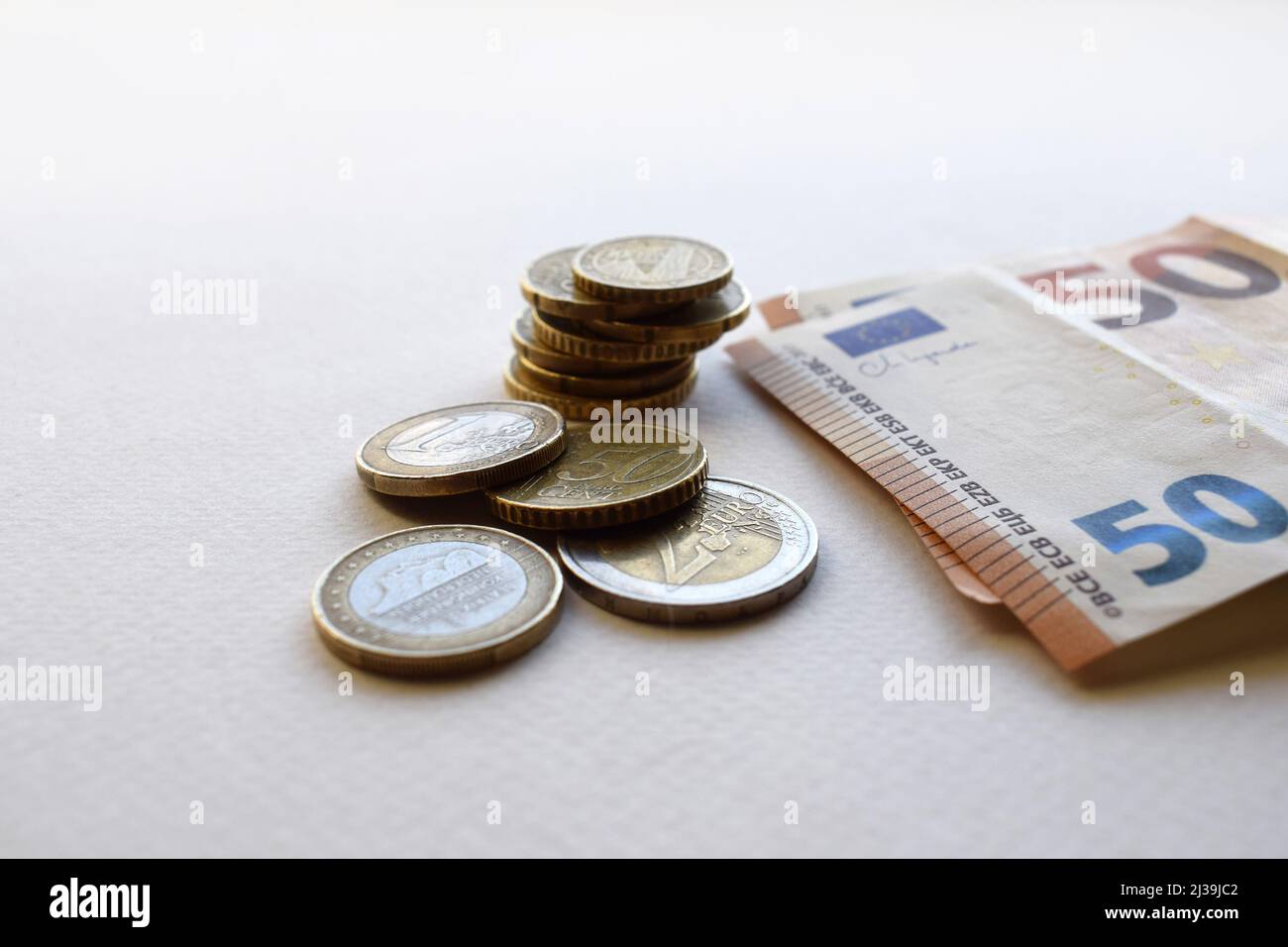 Konzept der Euro-Banknoten und -Münzen auf weißem Hintergrund ...
