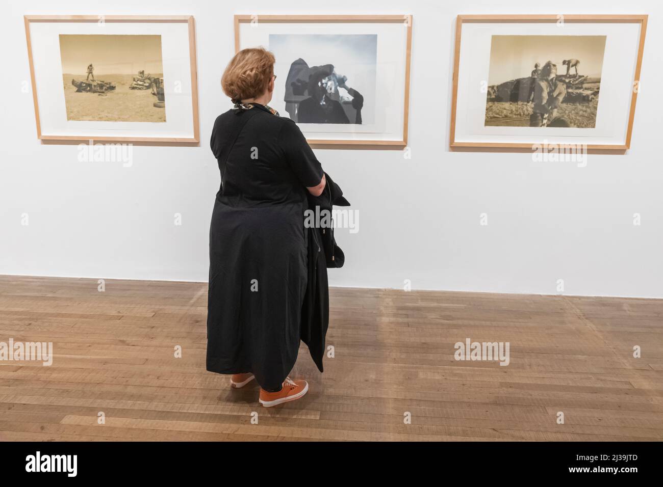 England, London, Southwark, Bankside, Tate Modern Art Gallery, Besucherin mit Blick auf die Fotoausstellung Stockfoto