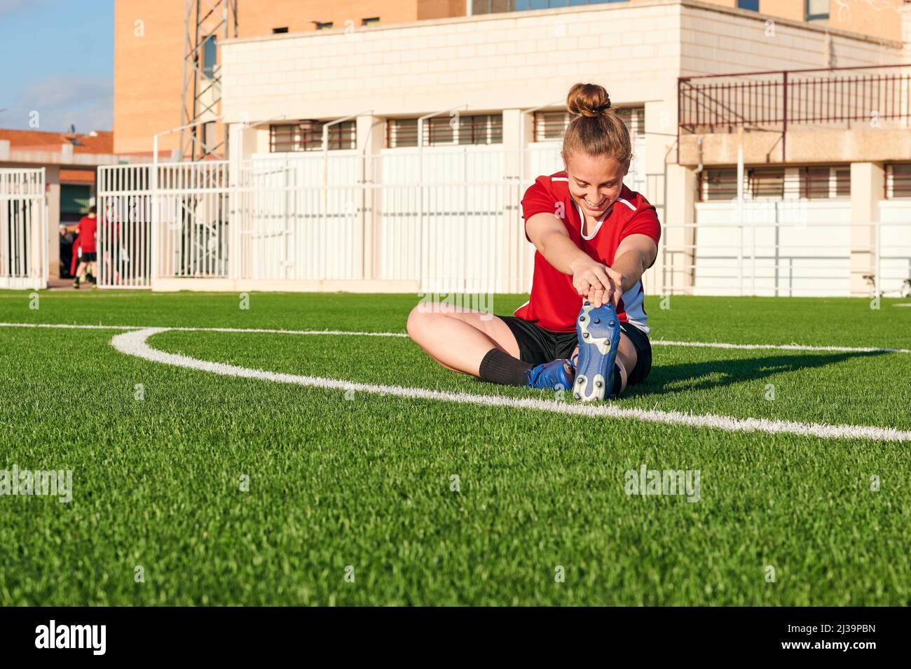 Eine Fußballspielerin dehnt sich während einer Trainingseinheit Stockfoto