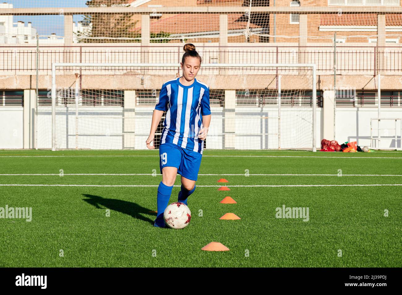 Eine Fußballspielerin trainiert auf einem Fußballfeld Stockfoto