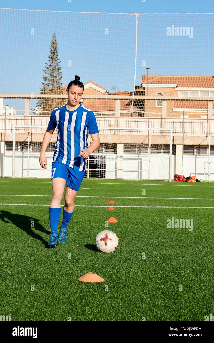 Eine Fußballspielerin trainiert auf einem Fußballfeld Stockfoto