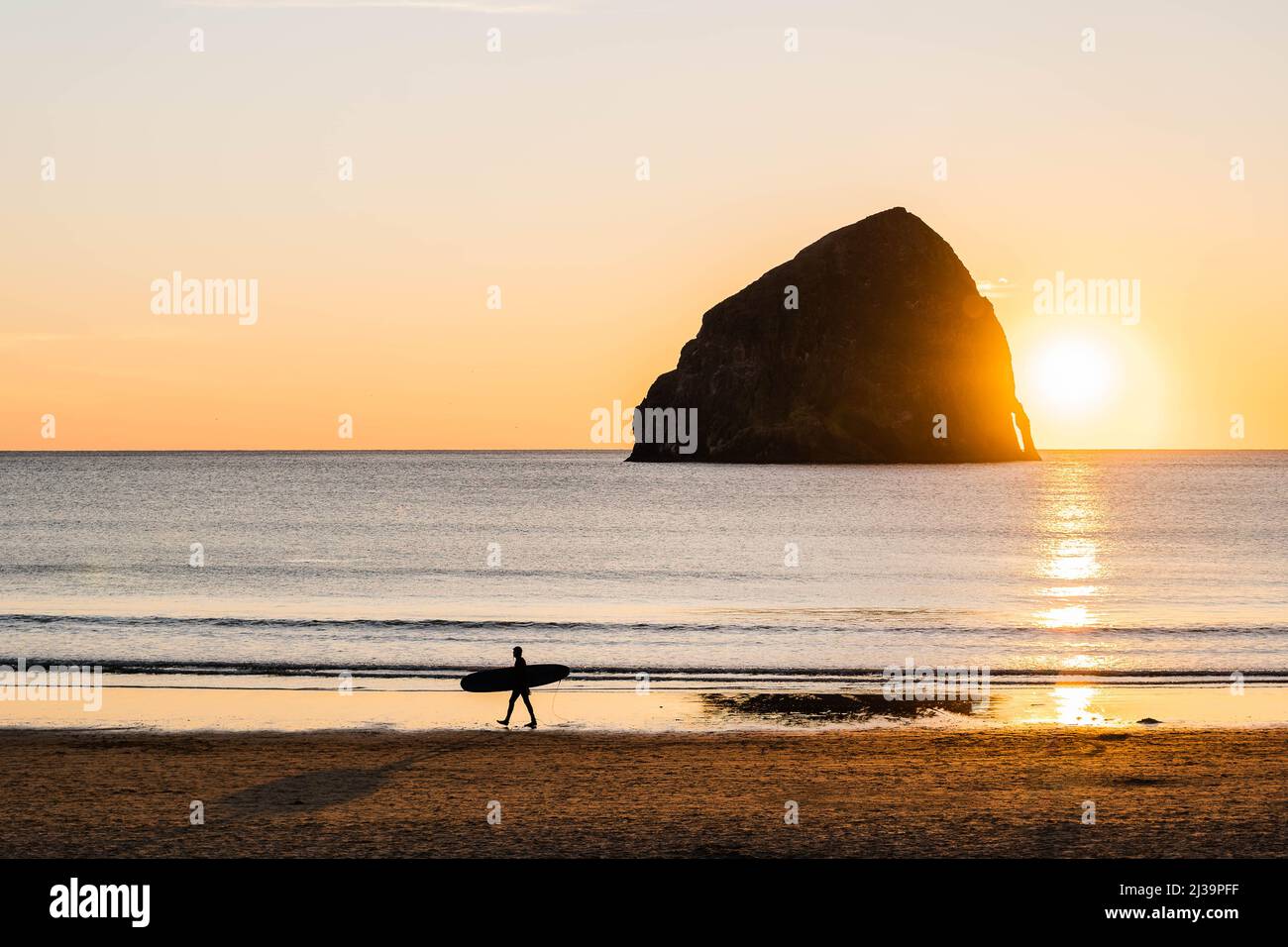 Surfer beim Sonnenuntergang am Strand in Pacific City, Oregon Stockfoto