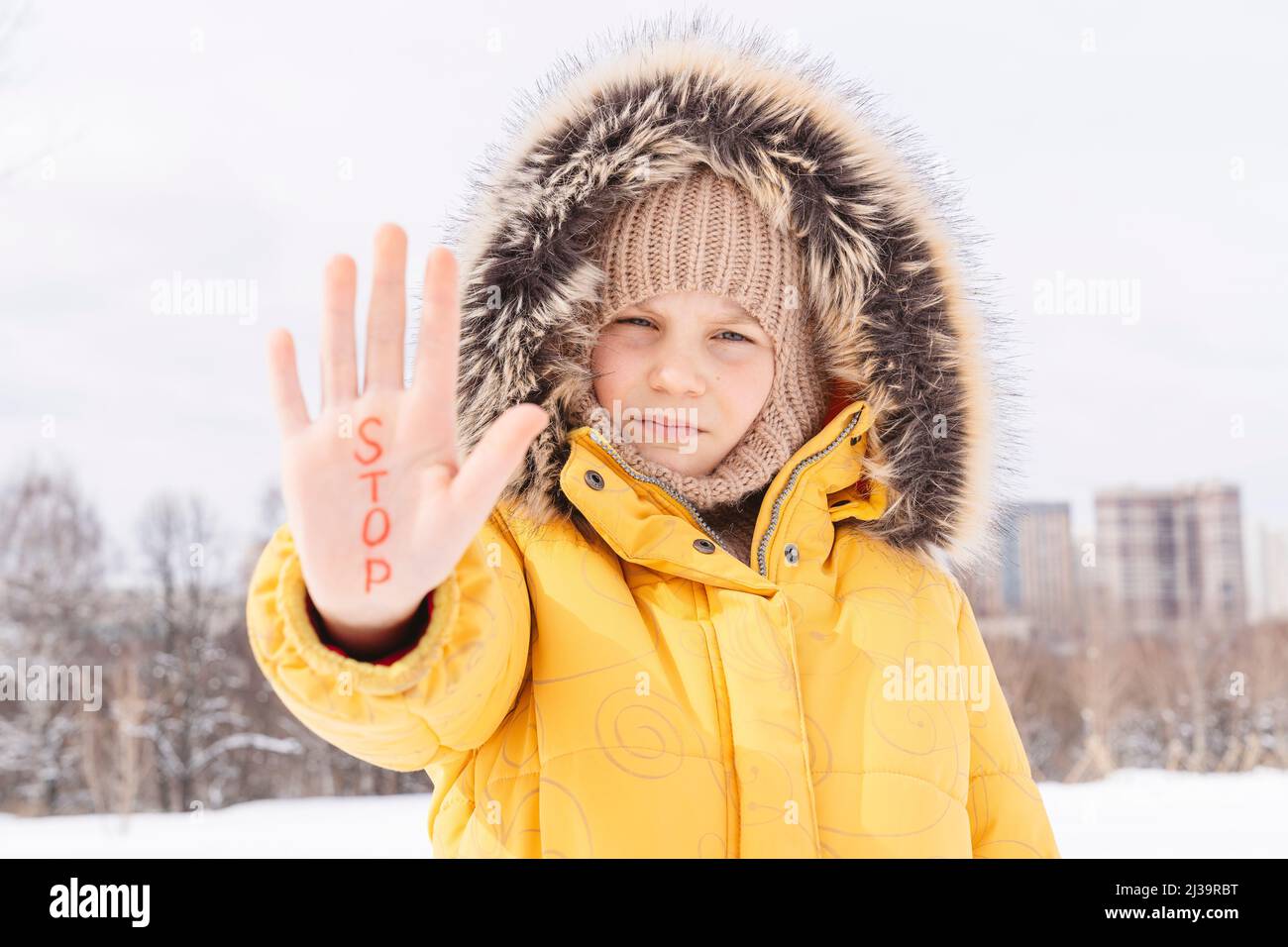 Das Mädchen zeigt ihre Handfläche mit der Aufschrift STOP. Stockfoto