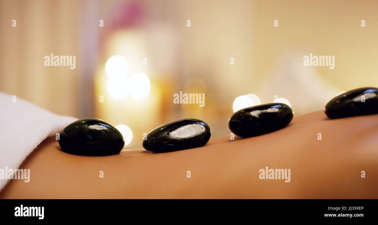 Je heißer der Stein, desto besser das Relief. Aufnahme einer unkenntlichen Frau, die in einem Beauty Spa eine Hot Stone Massage bekommt. Stockfoto
