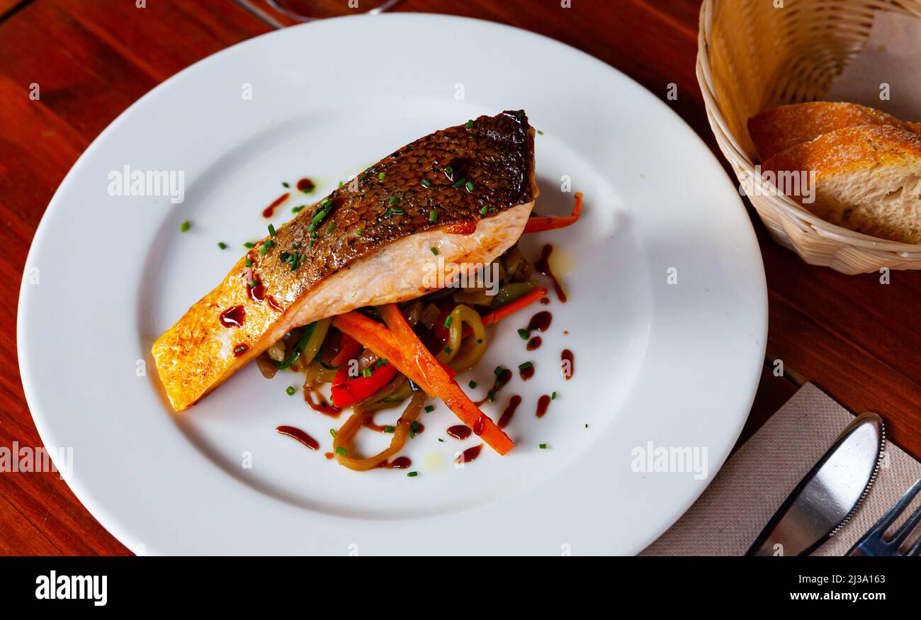 Gebackener Lachs mit sautiertem Gemüse Stockfoto