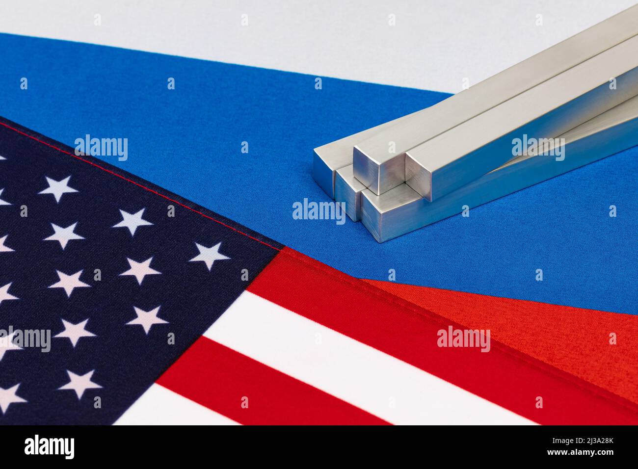 Aluminium-Metall und Flaggen der Vereinigten Staaten und Russland. Handelssanktionen, Metallexporte und Fertigungskonzept Stockfoto