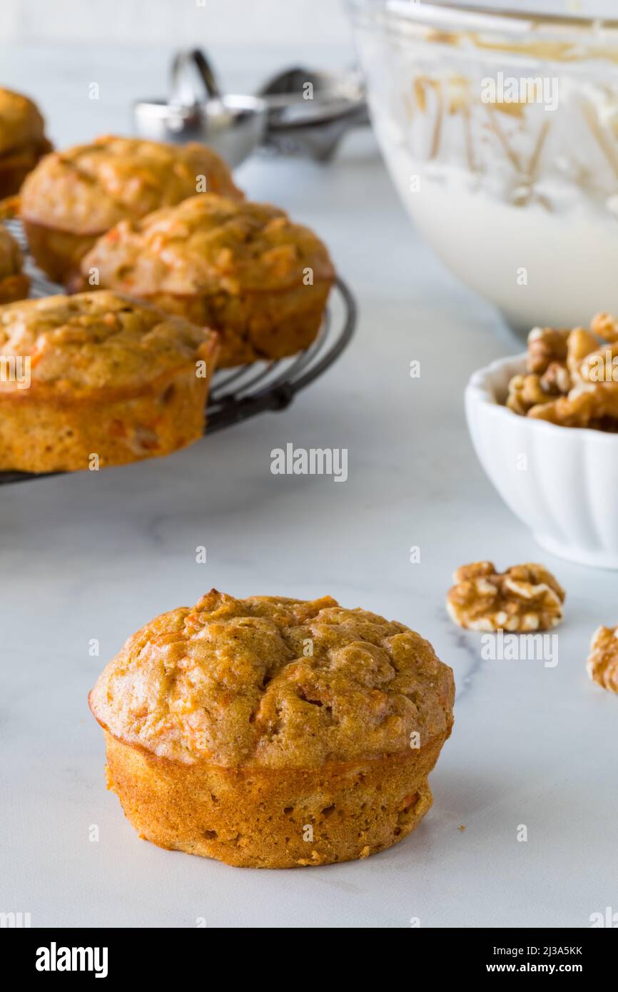 Karottenkuchenmuffins mit Frischkäse-Vereisung in einer Schüssel bereit zum Dekorieren. Stockfoto