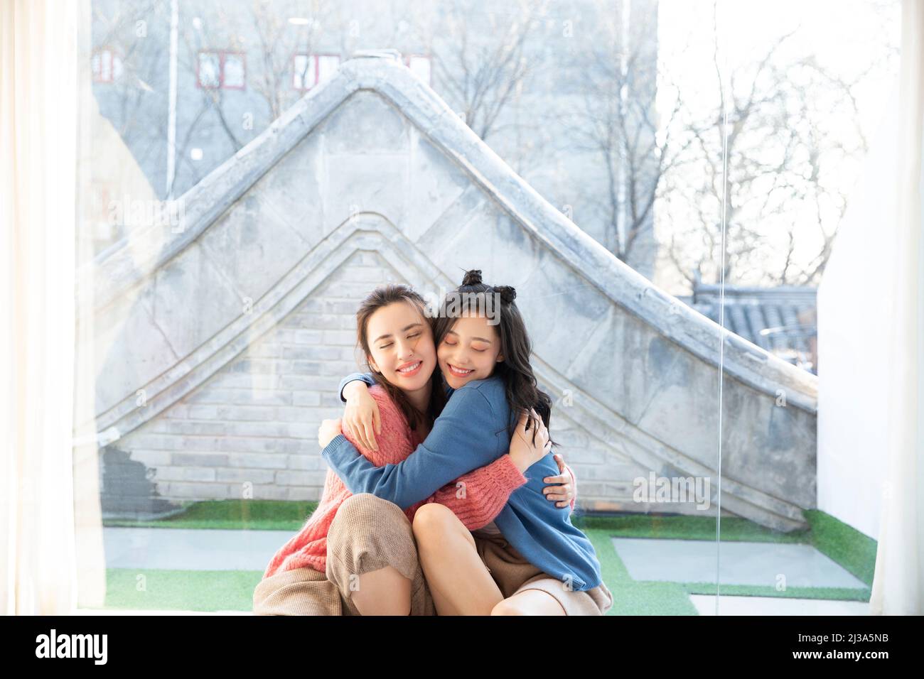 Wiedervereint nach einer langen Trennung, die Freizeit der schönen jungen modischen chinesischen Damen - Stock Foto Stockfoto