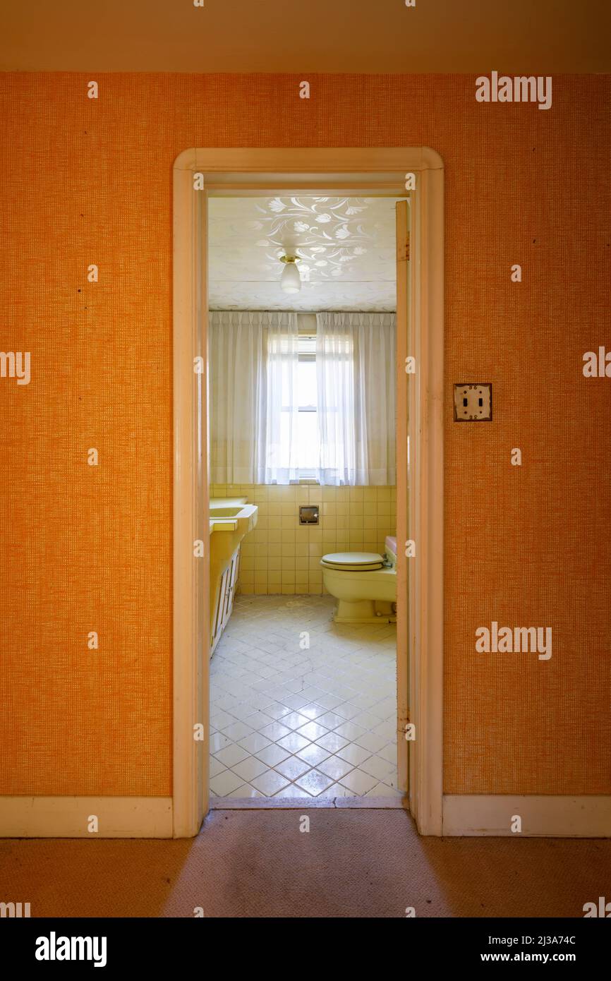 Ein Retro-Badezimmer aus den Jahren 1960s oder 1970s mit gelbem Thema. Dieses Haus wurde seitdem abgerissen. Stockfoto