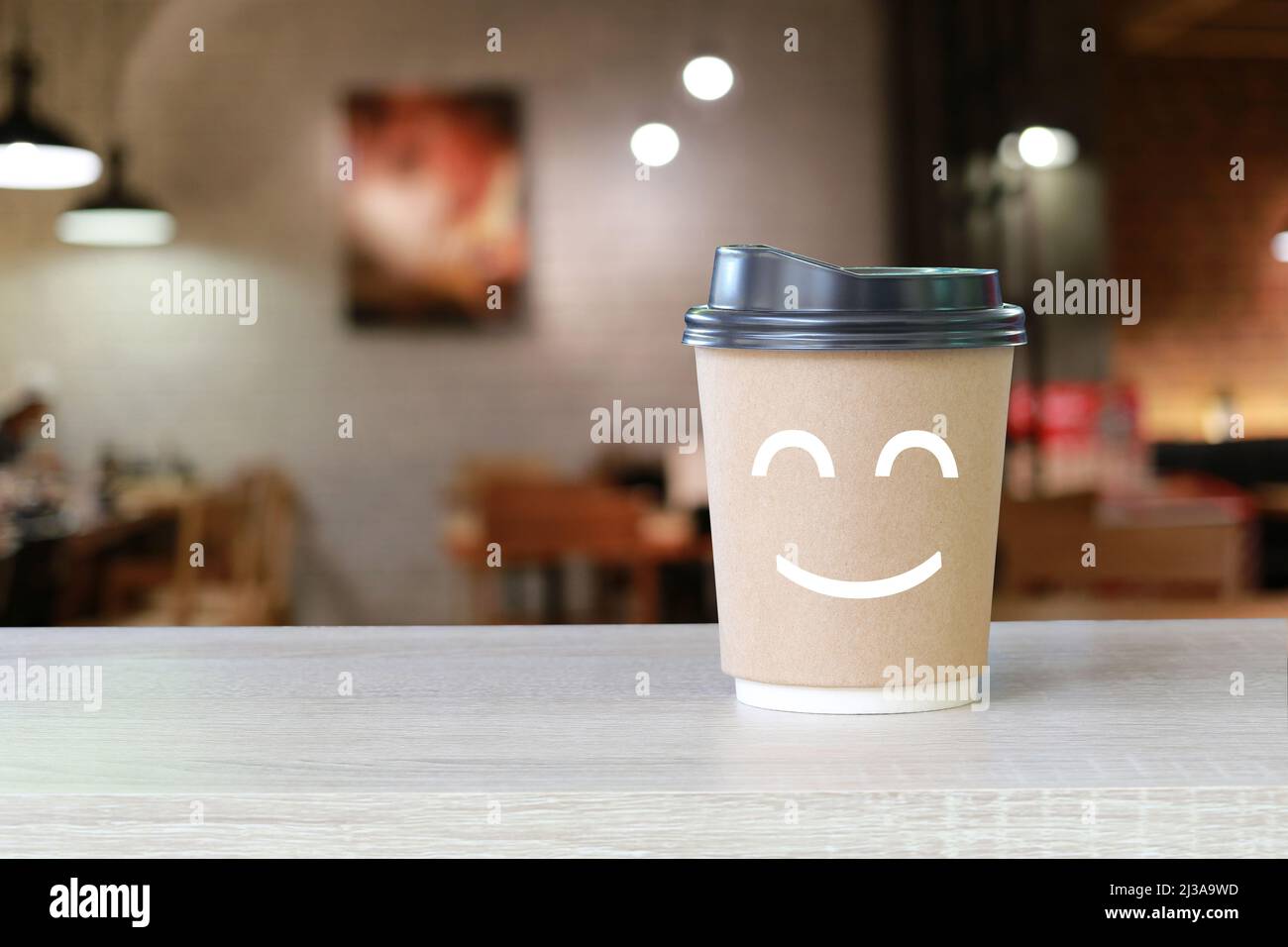 Papierbecher Kaffee auf dem Tisch mit Blur Cafe Hintergrund für Design in Ihrer Arbeit. Stockfoto