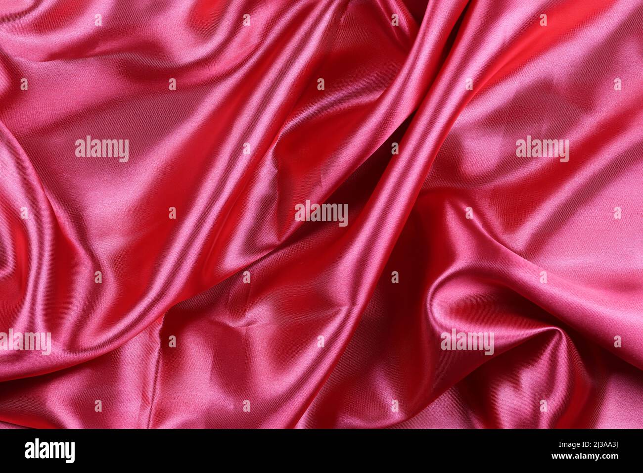 Roter, faltiger Stoffhintergrund für Design in Ihrem Arbeitskonzept. Stockfoto