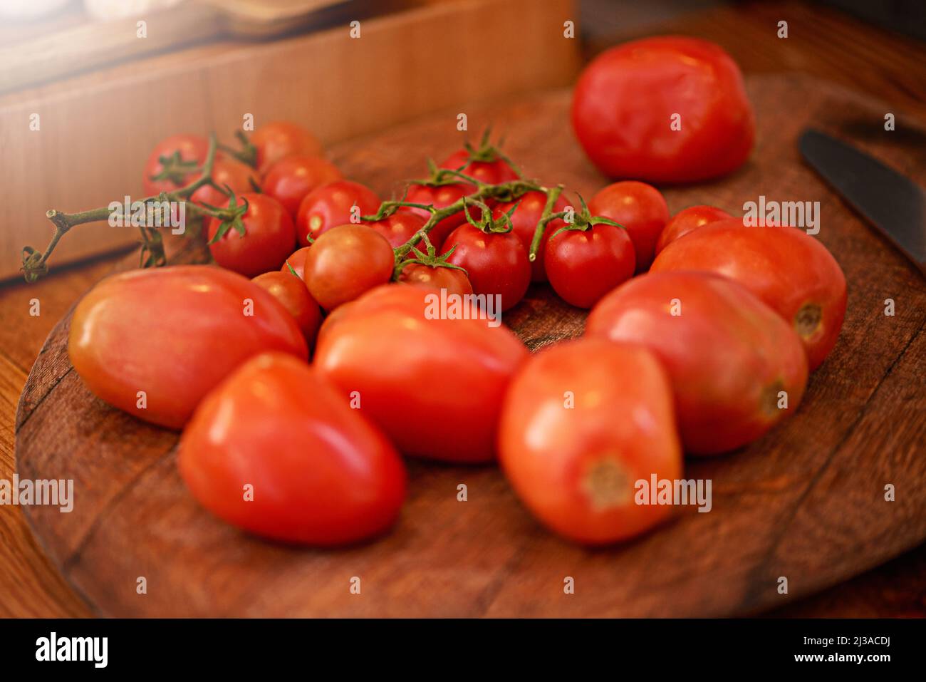 Perfekt prall gezupfte Tomaten. Schuss einer Pflaume und Kirschtomaten auf einem Tisch in einer Küche. Stockfoto