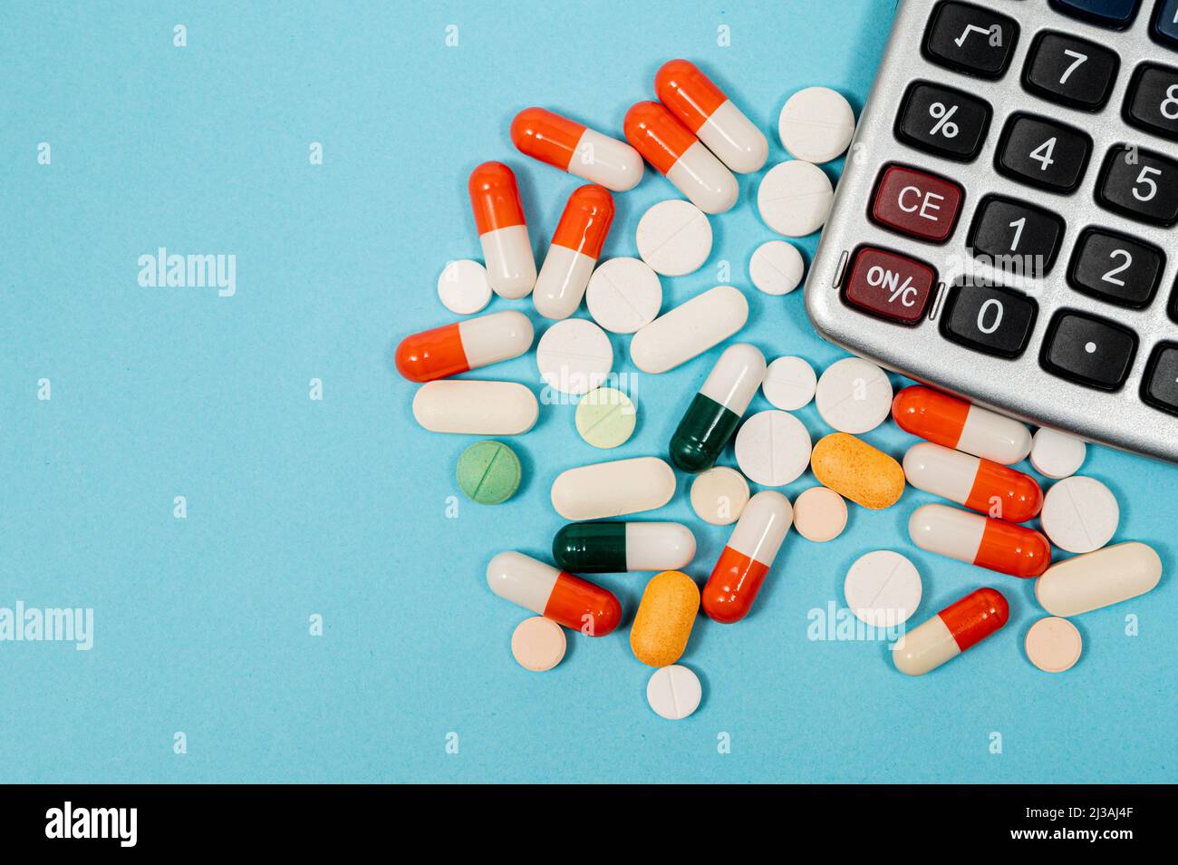 Medizinisches Konzept mit verschiedenen Medikamenten und Rechner auf blauem Hintergrund Stockfoto
