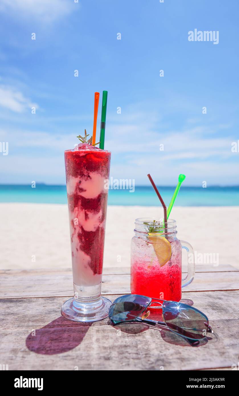 Frisches kaltes Getränk auf Holztisch und Sommer verschwommener Hintergrund des Strandes Stockfoto