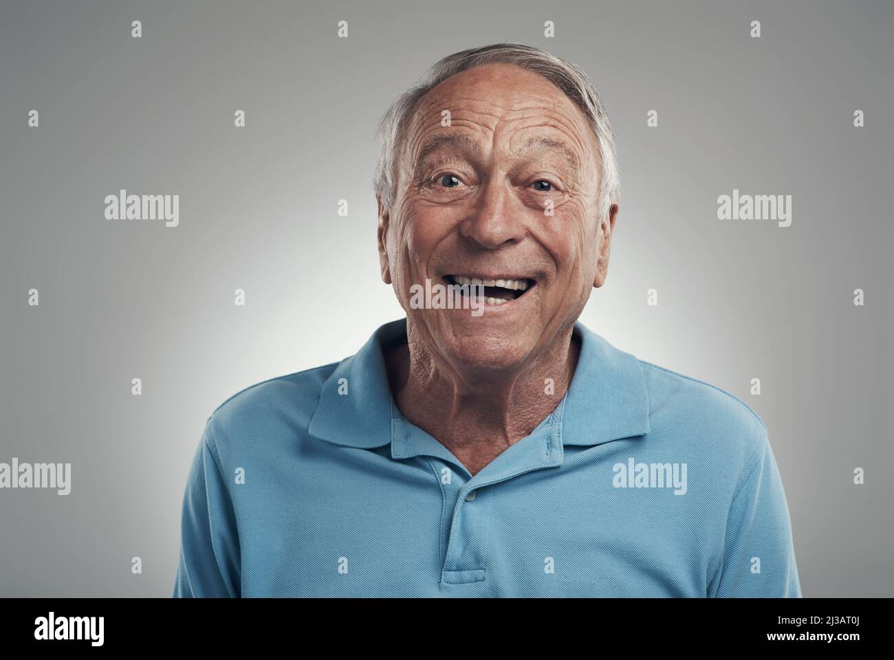 Zeit zum Lächeln. Aufnahme eines Mannes, der vor grauem Hintergrund fröhlich die Kamera in einem Studio anlächelt. Stockfoto