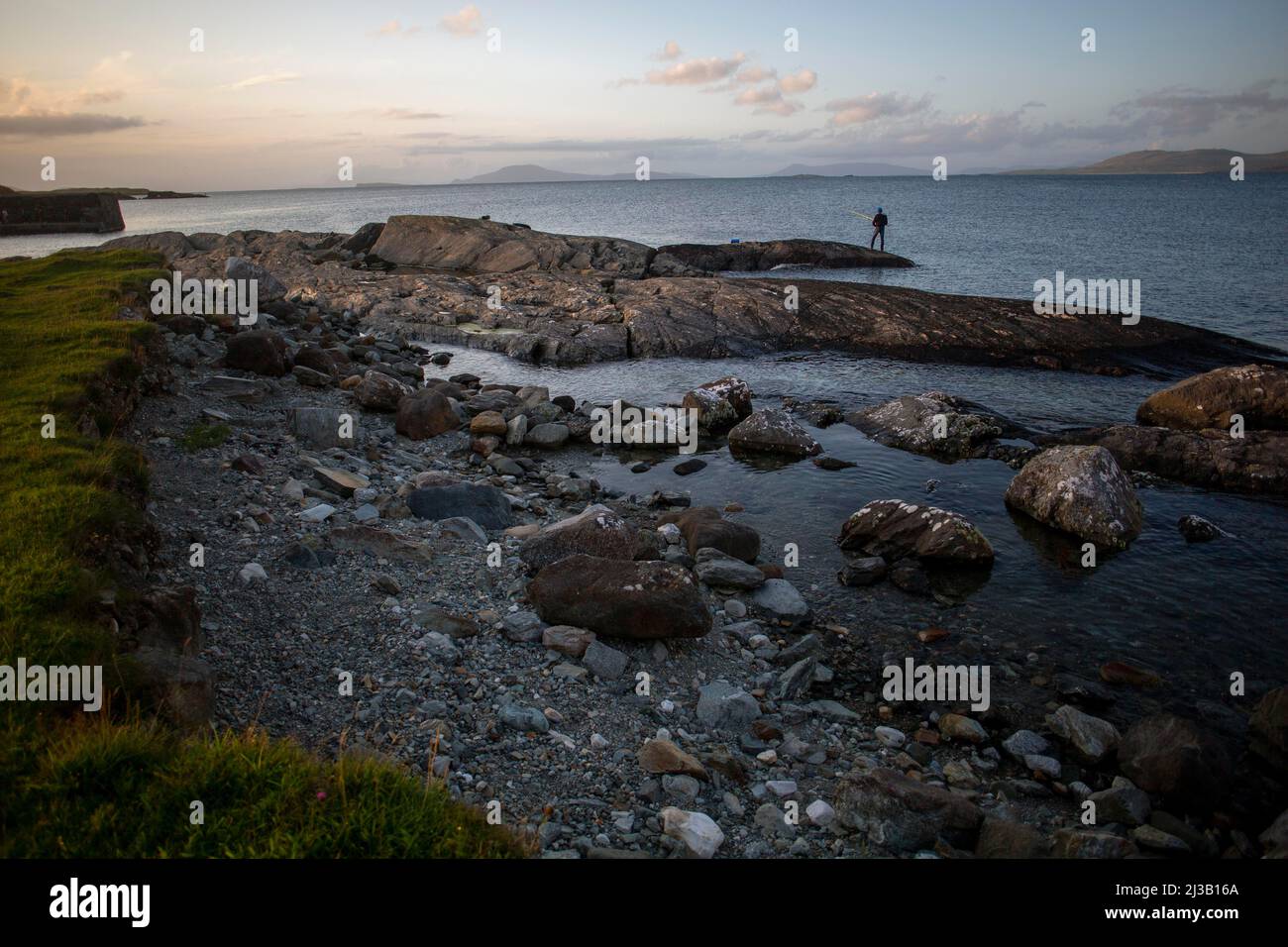 Mann, der am Sommerabend am Hafen von Renvyle entlang des Wild Atlantic Way angeln wird. Renvyle, County Galway, Irland Stockfoto