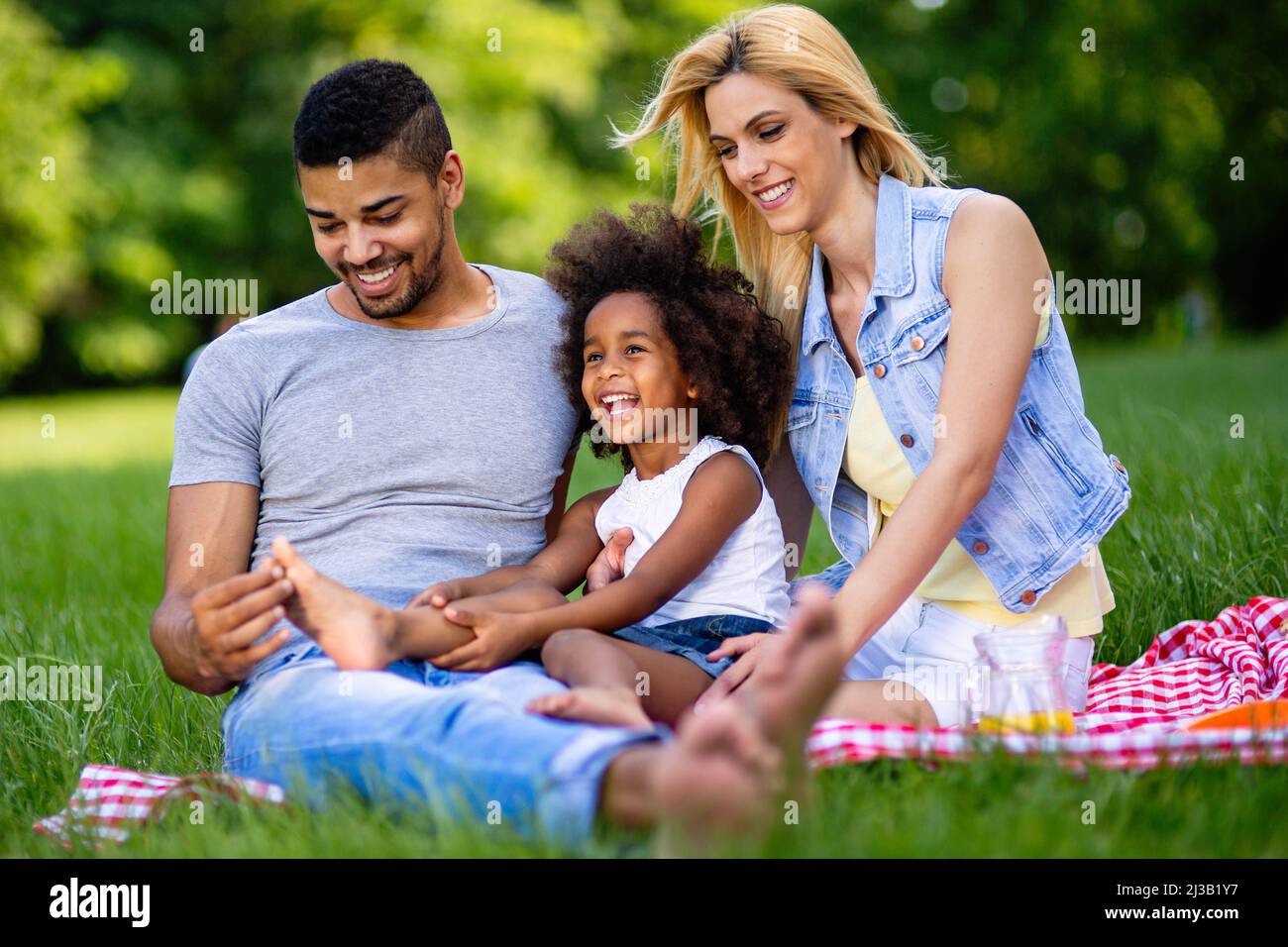 Glückliche multiethnische Familie genießt Picknick in der Natur Stockfoto