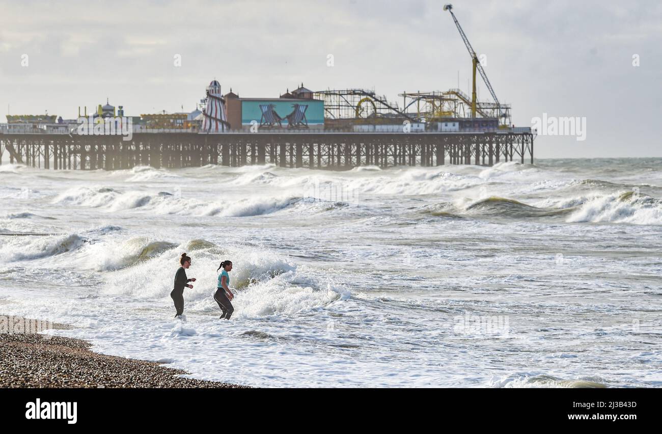 Brighton UK 7. April 2022 - Open Water Schwimmer genießen ein Bad im Meer in Brighton an einem stürmischen Tag nach einer Nacht mit starken Winden und Regen entlang der Südküste : Credit Simon Dack / Alamy Live News Stockfoto