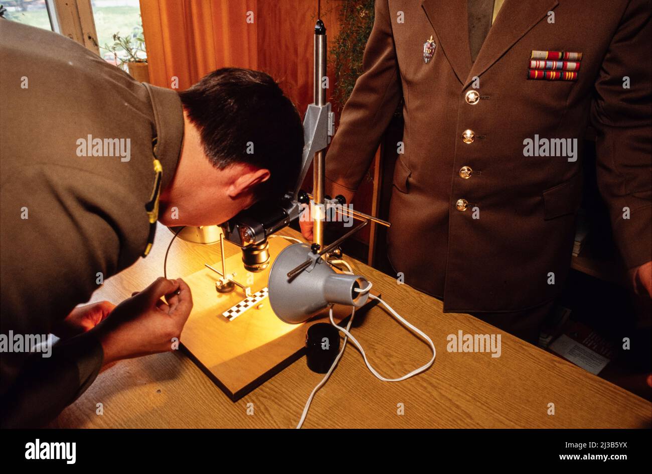 KGB-Ausbildungsschule, Moskau, Russland, UdSSR 1990. Professor und Studenten in der fotoforensischen Abteilung, die eine Kugel für einen Tatort suchen. Stockfoto