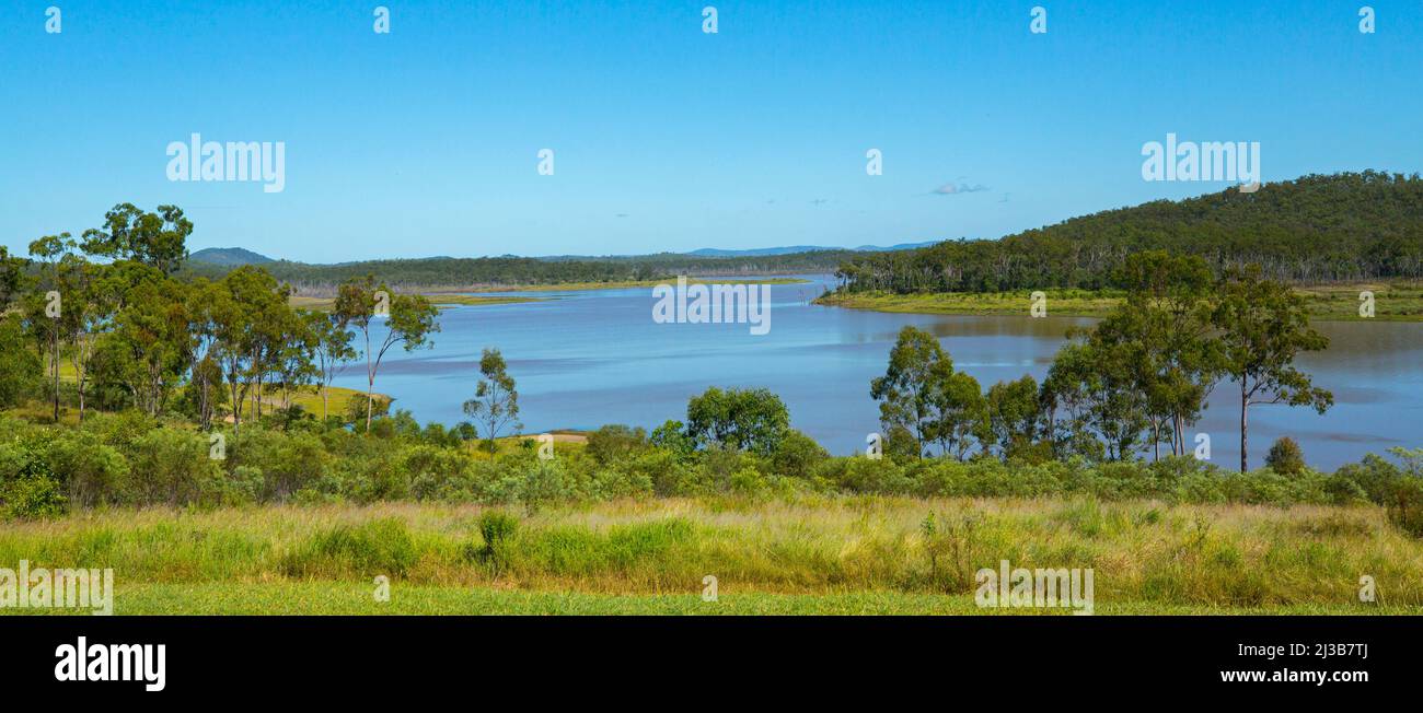 Atemberaubender Panoramablick auf das weite blaue Wasser des Sees am Staudamm Paradise, umgeben von bewaldeten Hügeln und unter blauem Himmel in Australien Stockfoto