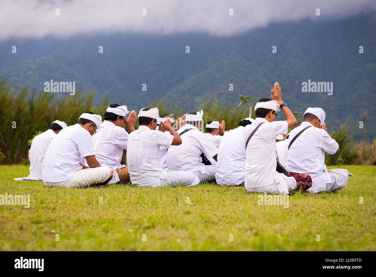 Männer beten in weiß gekleidet am Pura Bratan Tempel auf dem See in Bali, Indonesien Stockfoto