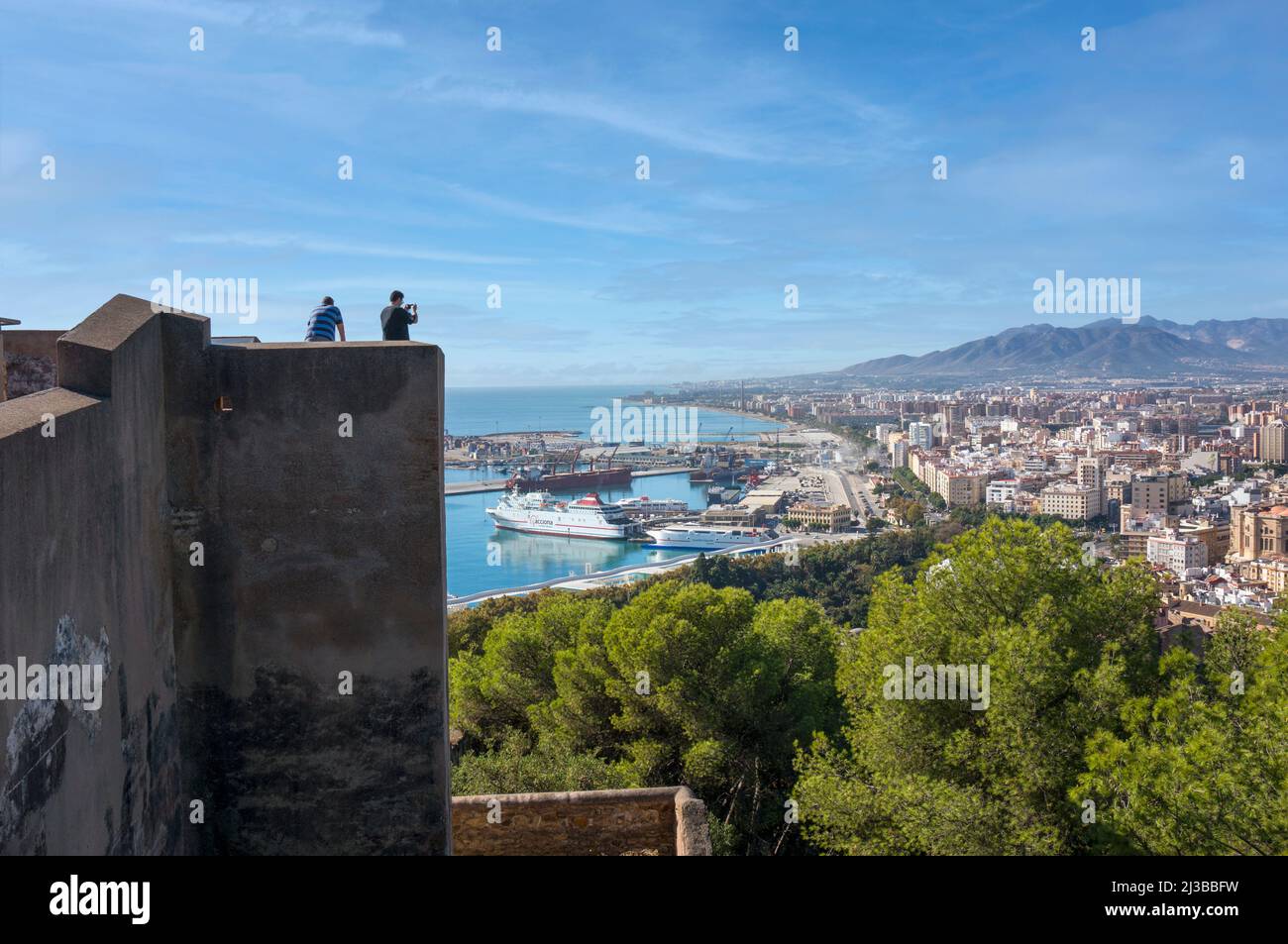 Malaga, Costa del Sol, Provinz Malaga, Andalusien, Südspanien. Touristen an den Mauern der Gibralfaro-Burg mit Blick auf die Stadt und den Hafen Stockfoto