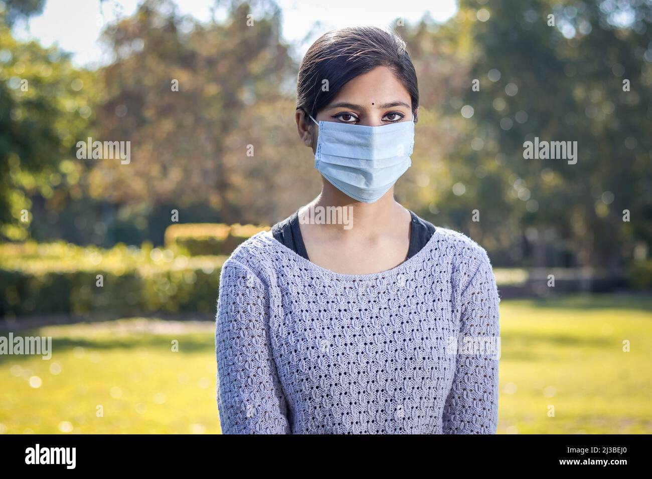 Indische Teenager Teenager Mädchen junge Frau trägt eine Gesichtsmaske draußen während der Coronavirus COVID-19 Virus Pandemie. Stockfoto