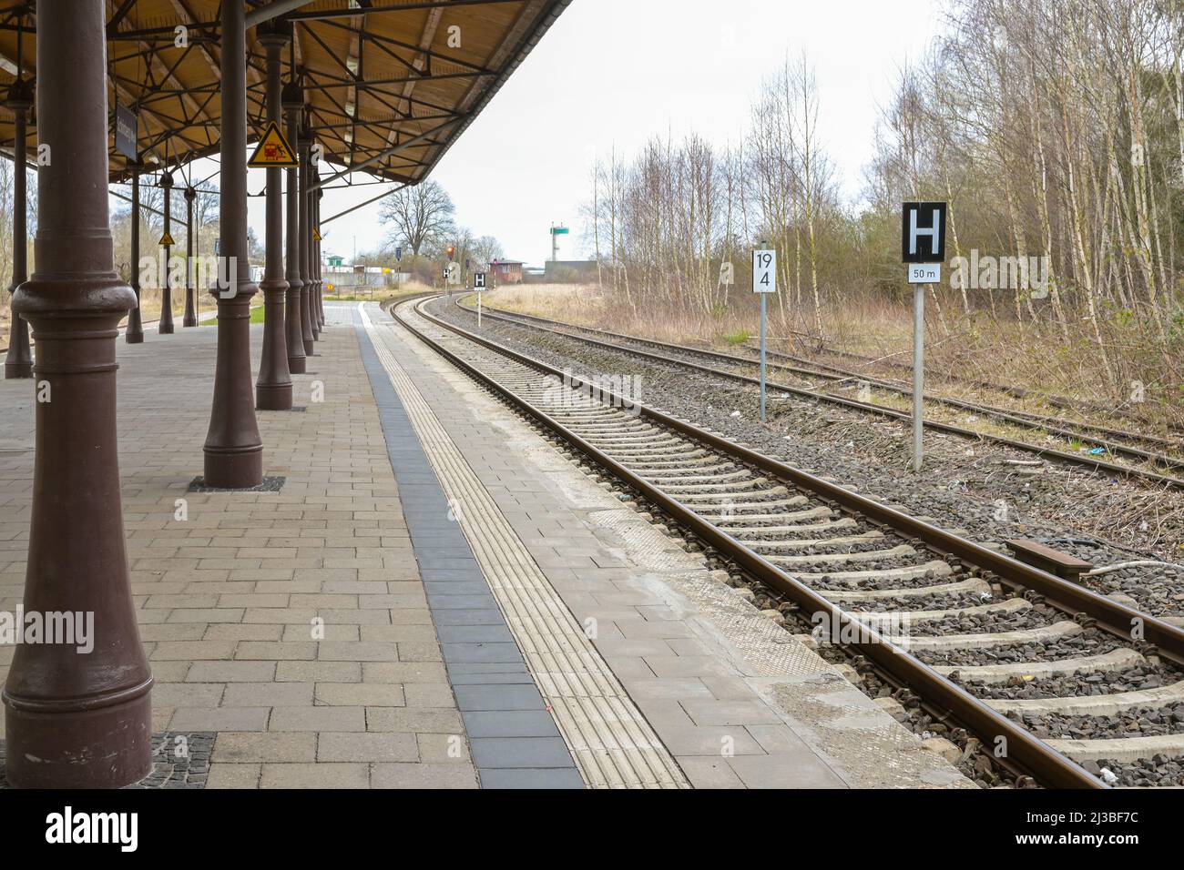 Überdachte Plattform mit Vintage-Metallsäulen an den Bahngleisen auf dem kleinen Landbahnhof in Schonberg, Mecklenburg, Deutschland, ausgewählter Fokus, na Stockfoto
