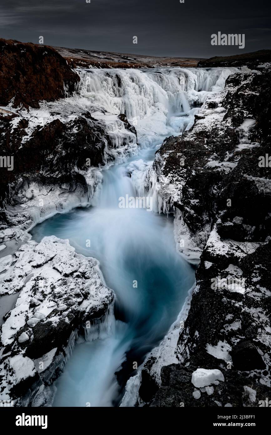 Ikonischer Kolufossar Wasserfall im Winter mit Schnee und Eis. Stockfoto