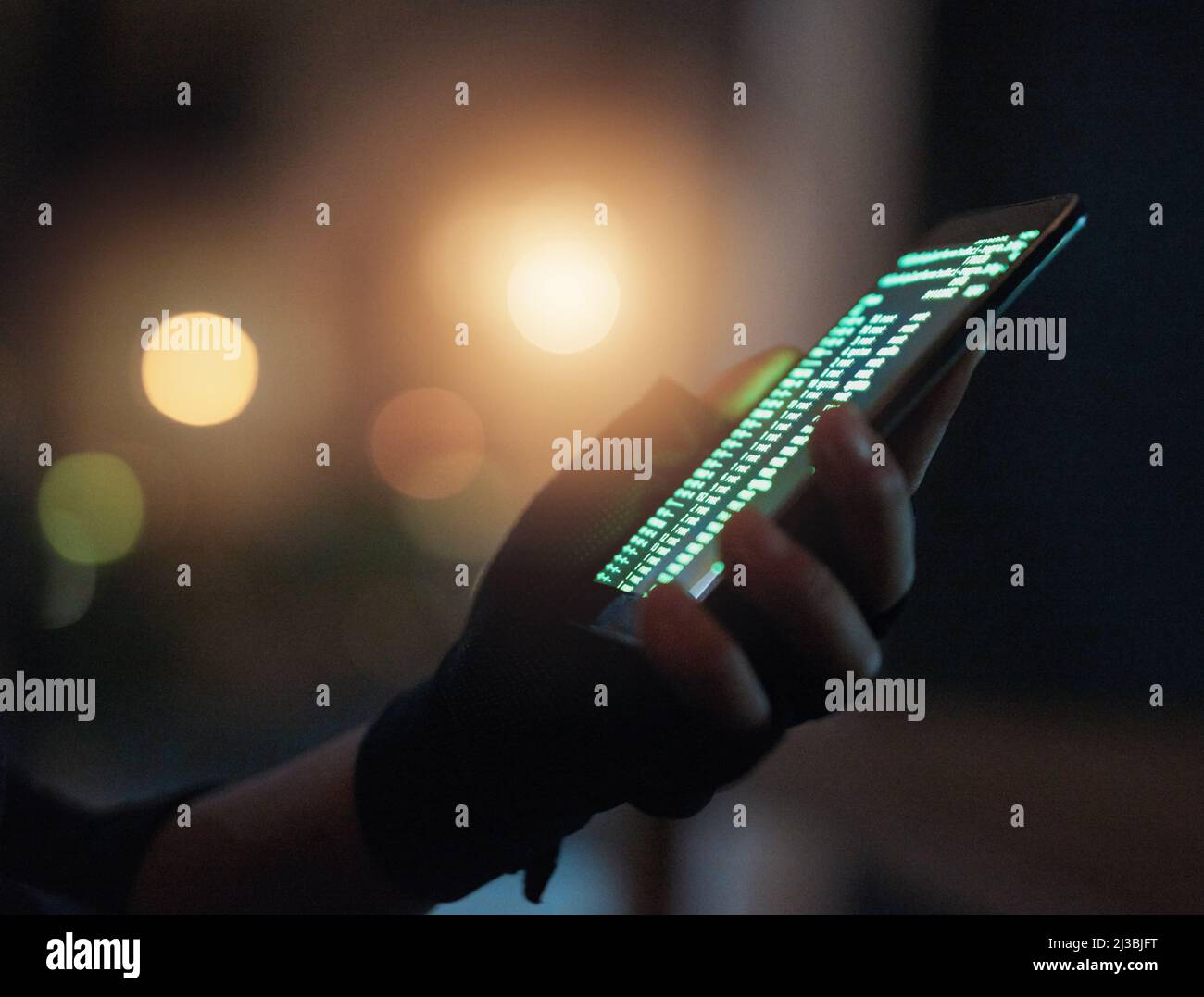 Schützen Sie sich vor Betrügern. Aufnahme eines nicht erkennbaren Hackers, der im Dunkeln ein Handy benutzt. Stockfoto