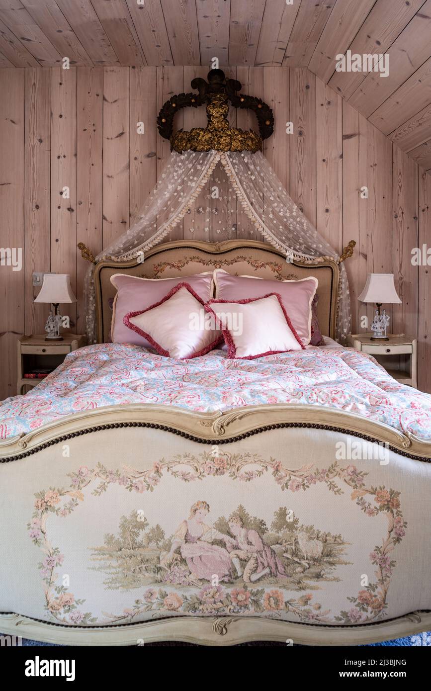 Bett im Louis XV-Stil mit französischer vergoldeter Metallcorona aus dem 19.. Jahrhundert und mit kanadischen Kiefern verkleideten Wänden, Holland Park, London, Großbritannien Stockfoto