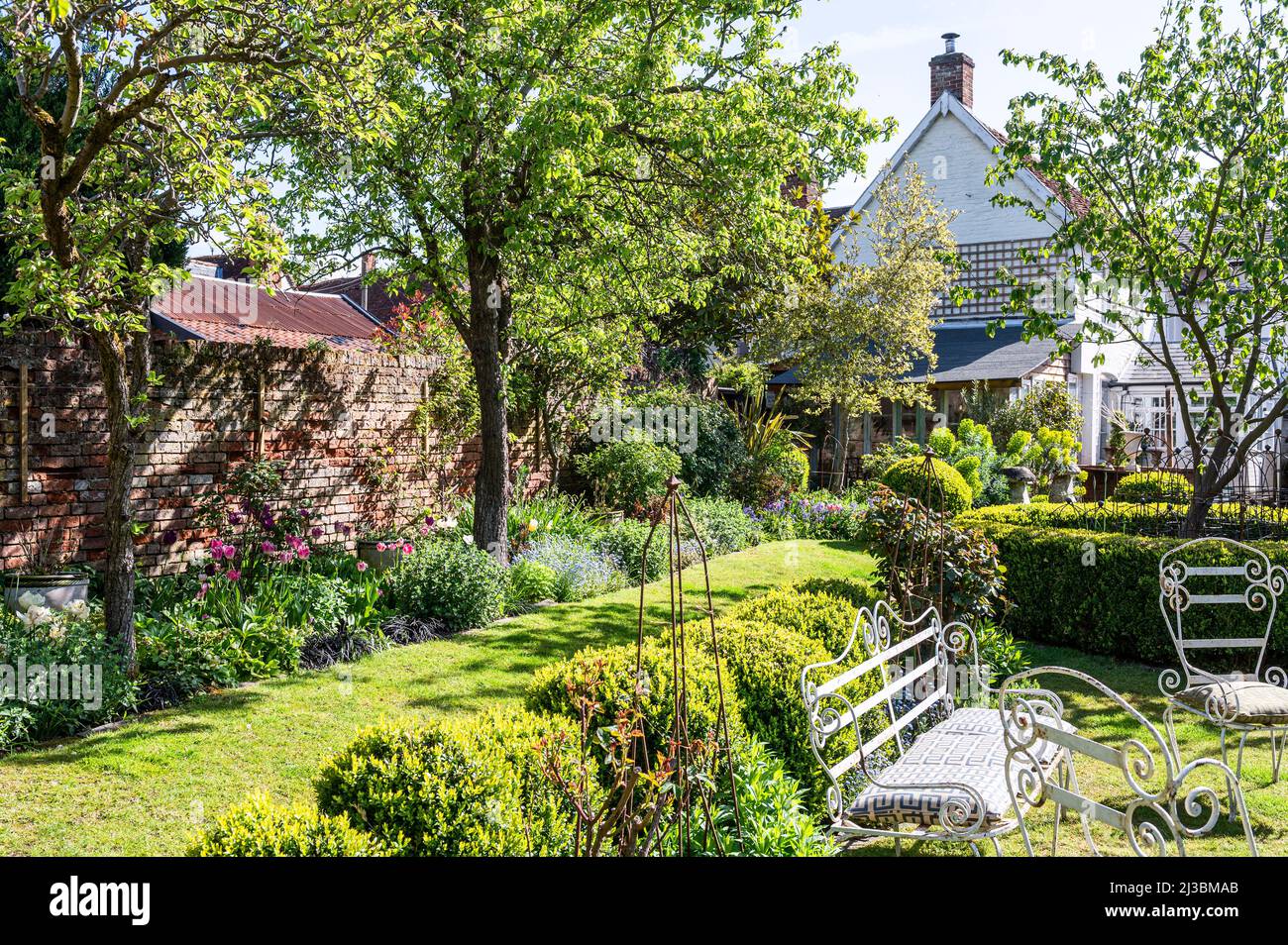 Gartenmöbel und sonnenbeschienenen Bäumen. Frühling in Suffolk, England, Vereinigtes Königreich Stockfoto