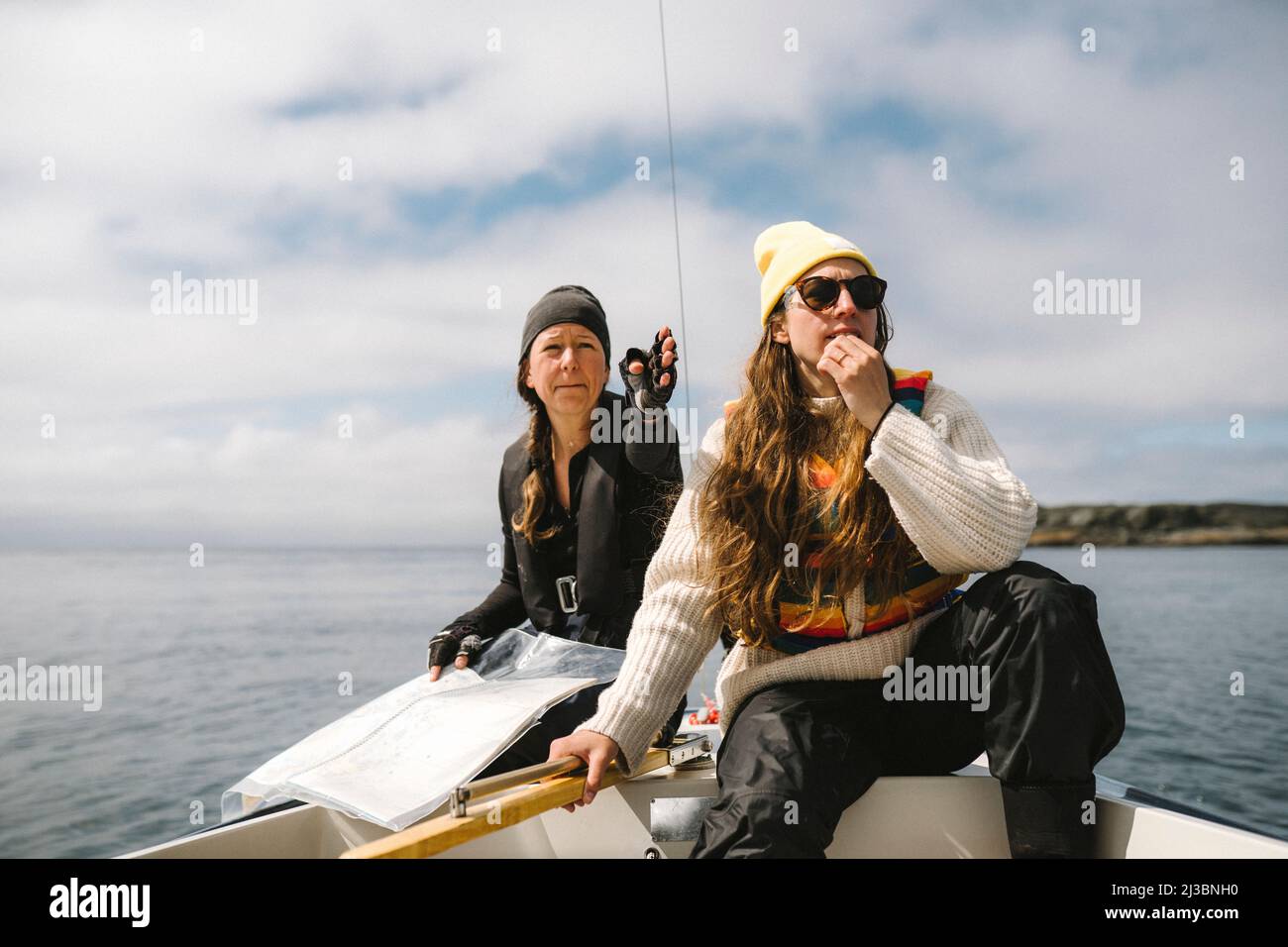 Frauen sitzen auf dem Boot und verwenden Karte, um die Richtung festzulegen Stockfoto