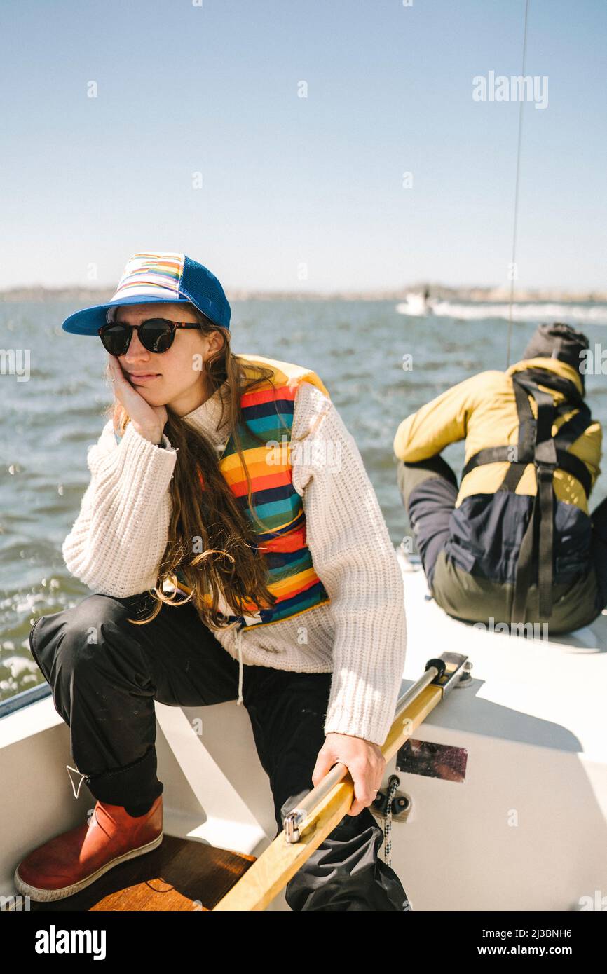 Junge Frau sitzt auf Boot Stockfoto