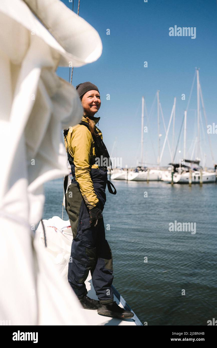 Lächelnde Frau auf dem Boot in der Marina Stockfoto