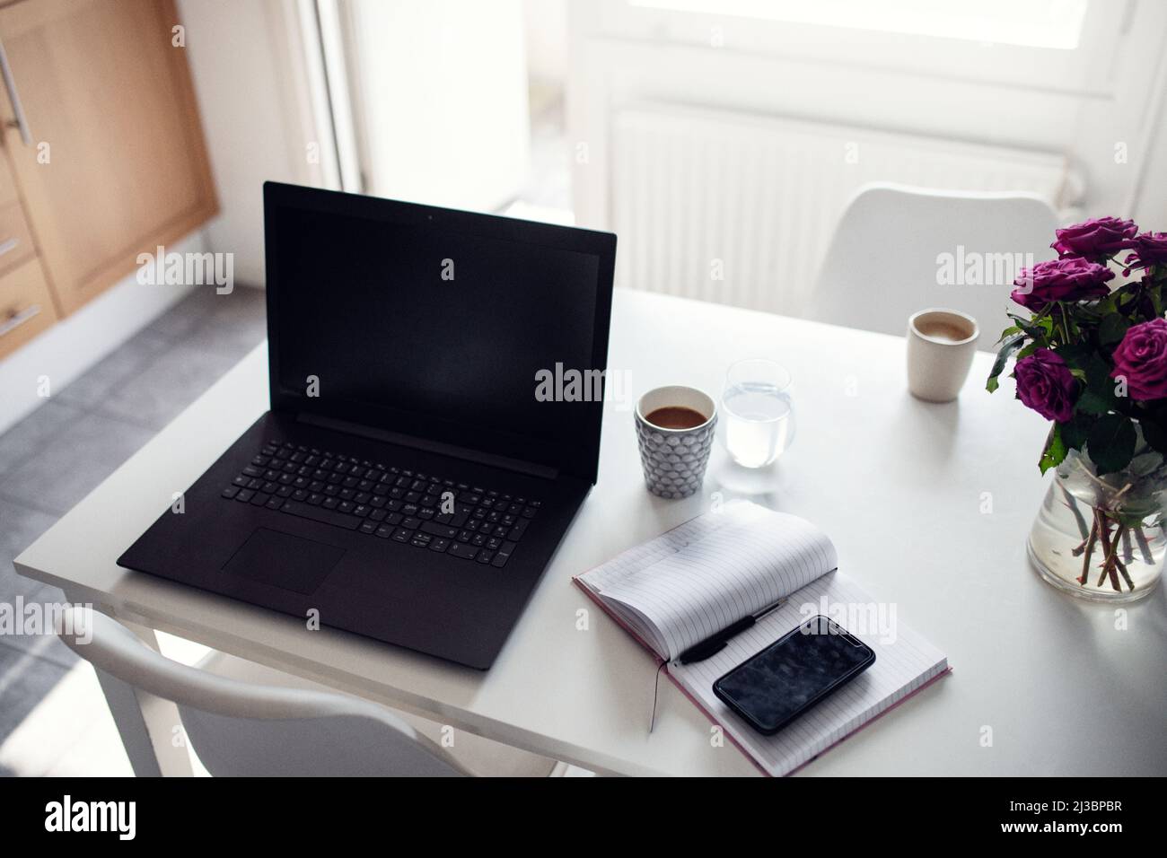 Laptop und Tagebuch auf Küchentisch Stockfoto