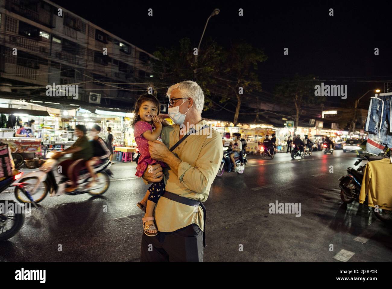 Großvater hält Enkelin nachts auf der Straße Stockfoto